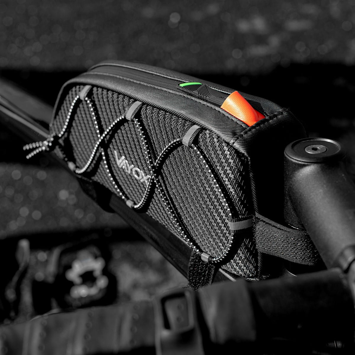 Czarna torba rowerowa zamontowana na kierownicy roweru, czarno-białe tło.