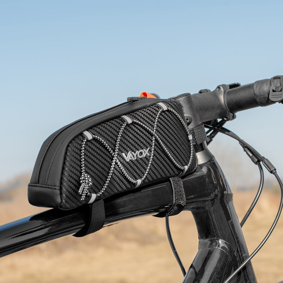 Czarna torba rowerowa na kierownicy, ze wzorem z włókna węglowego i marką 'VAYOX'.