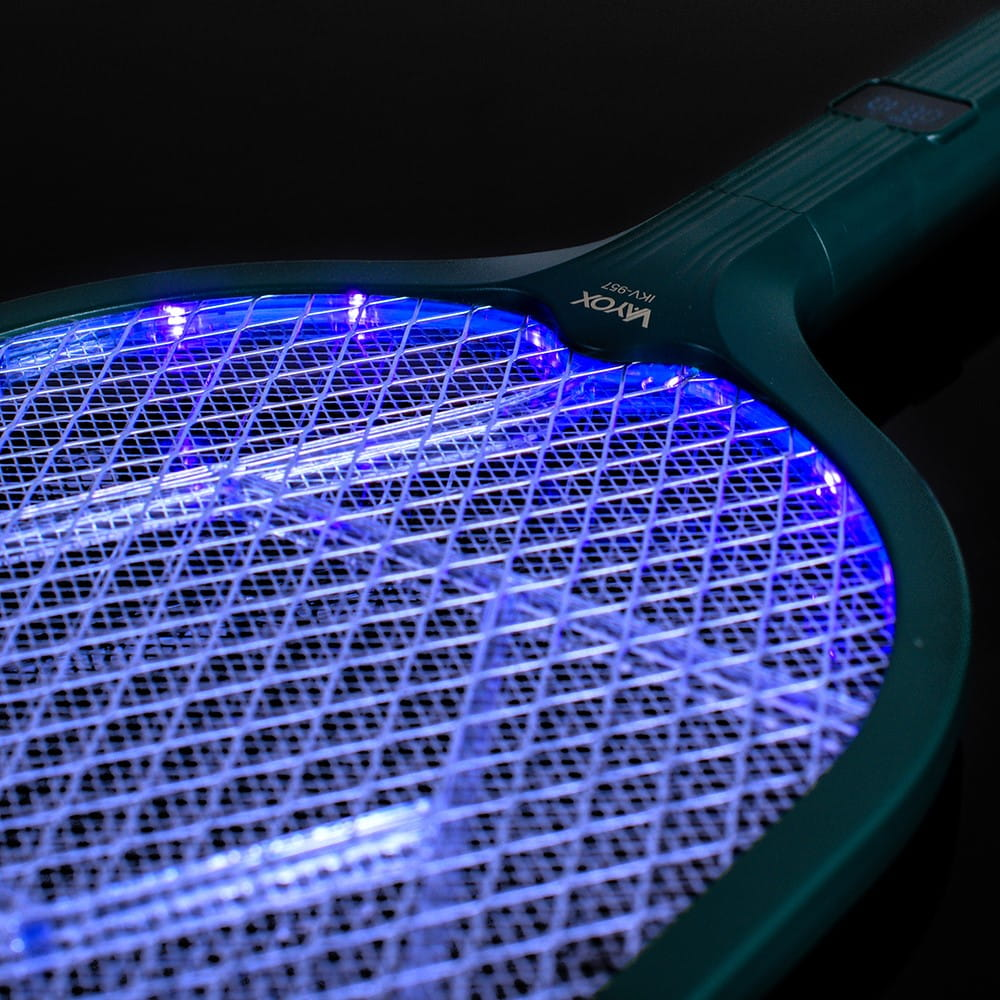 Zielona elektryczna packa na komary z niebieskim światłem. Czarne tło. Zbliżenie.