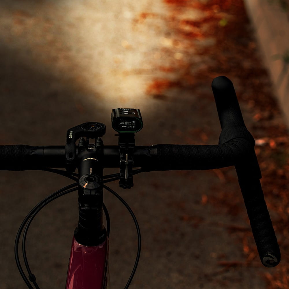 Kierownica roweru ze światłami. Urządzenie Garmin jest zamontowane po lewej stronie.