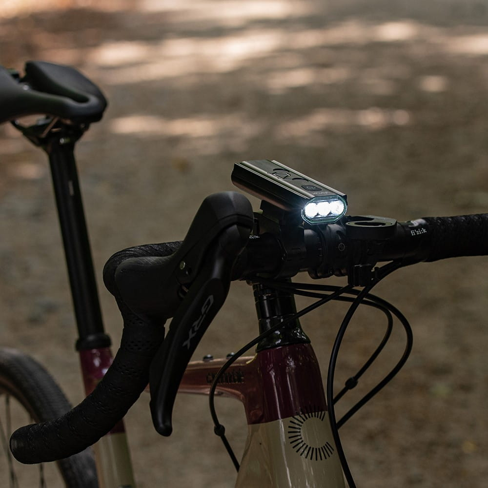 Kierownica roweru ze światłem. Światło jest czarne i ma trzy światła.