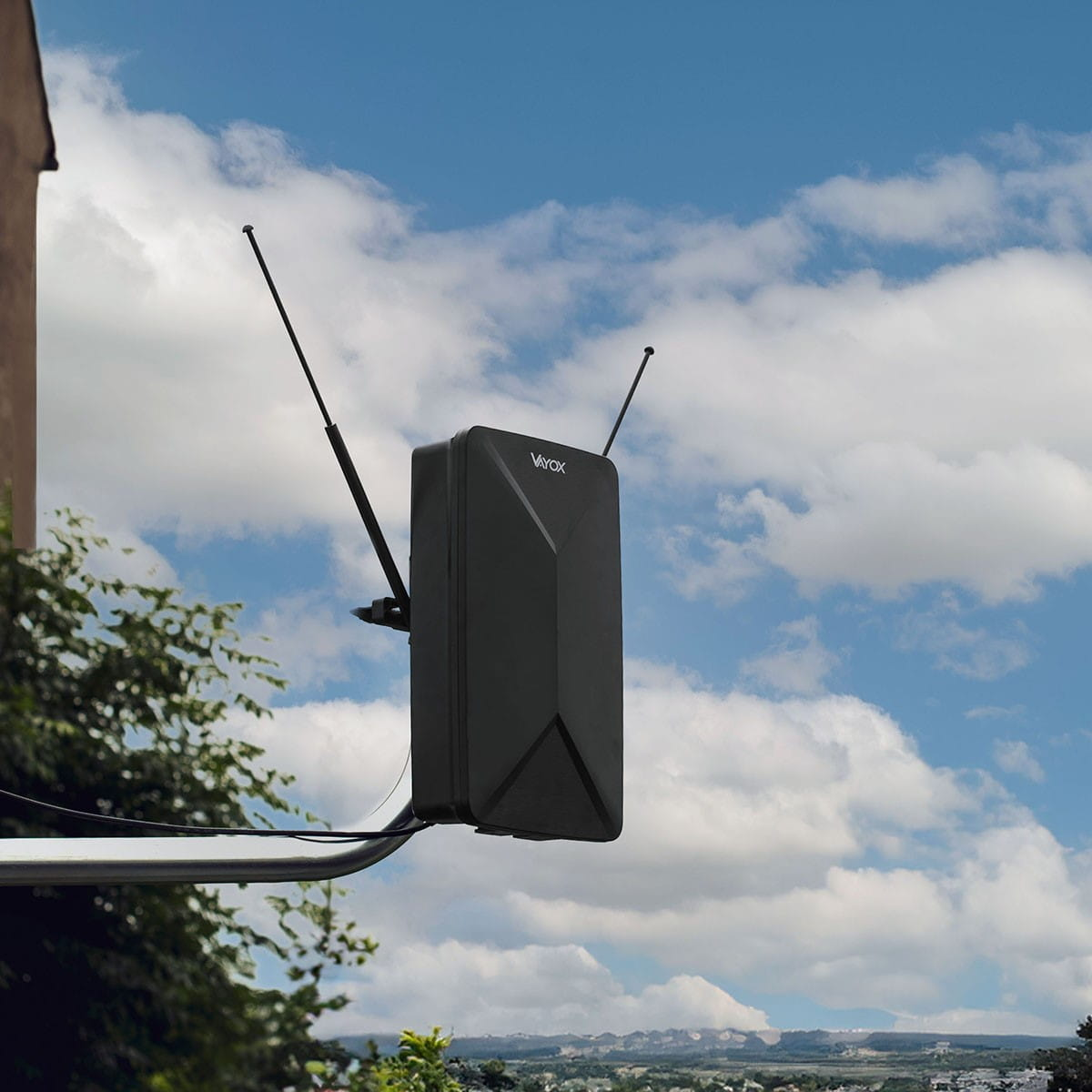 Czarna antena zewnętrzna, zamontowana na metalowym ramieniu, na tle pochmurnego nieba.