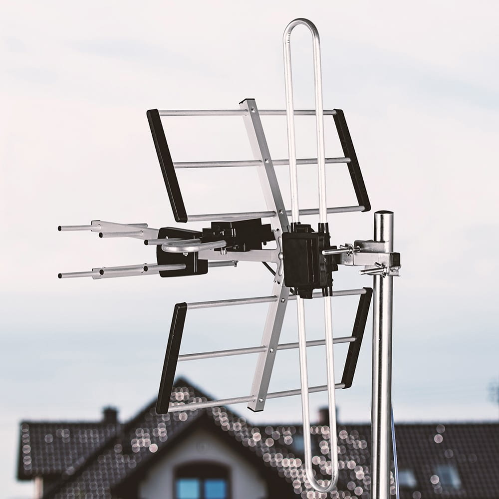 Antena zewnętrzna z metalową ramą, umieszczona na tle nieba i domu.