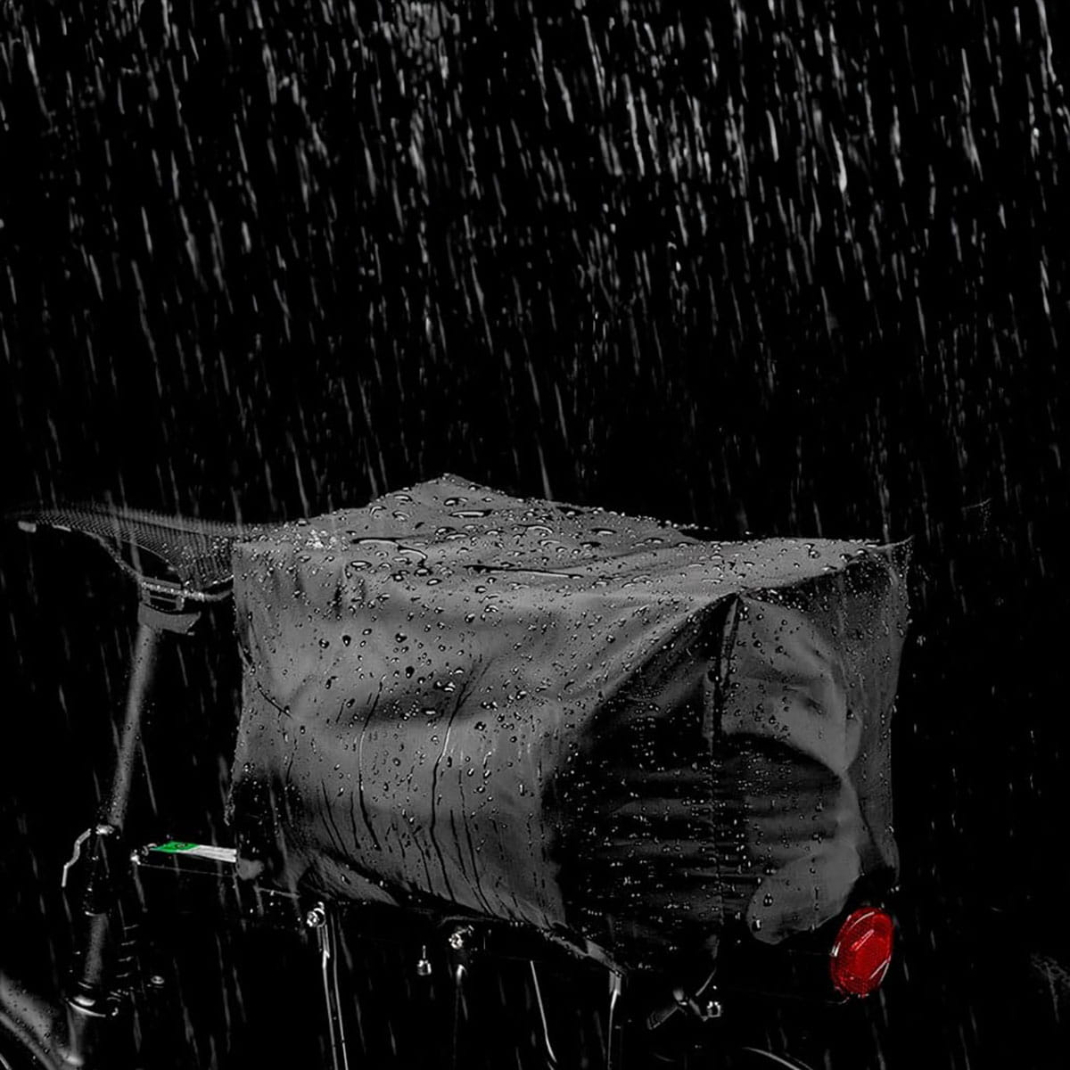 Czarna, wodoodporna torba rowerowa na rowerze. Pada deszcz.