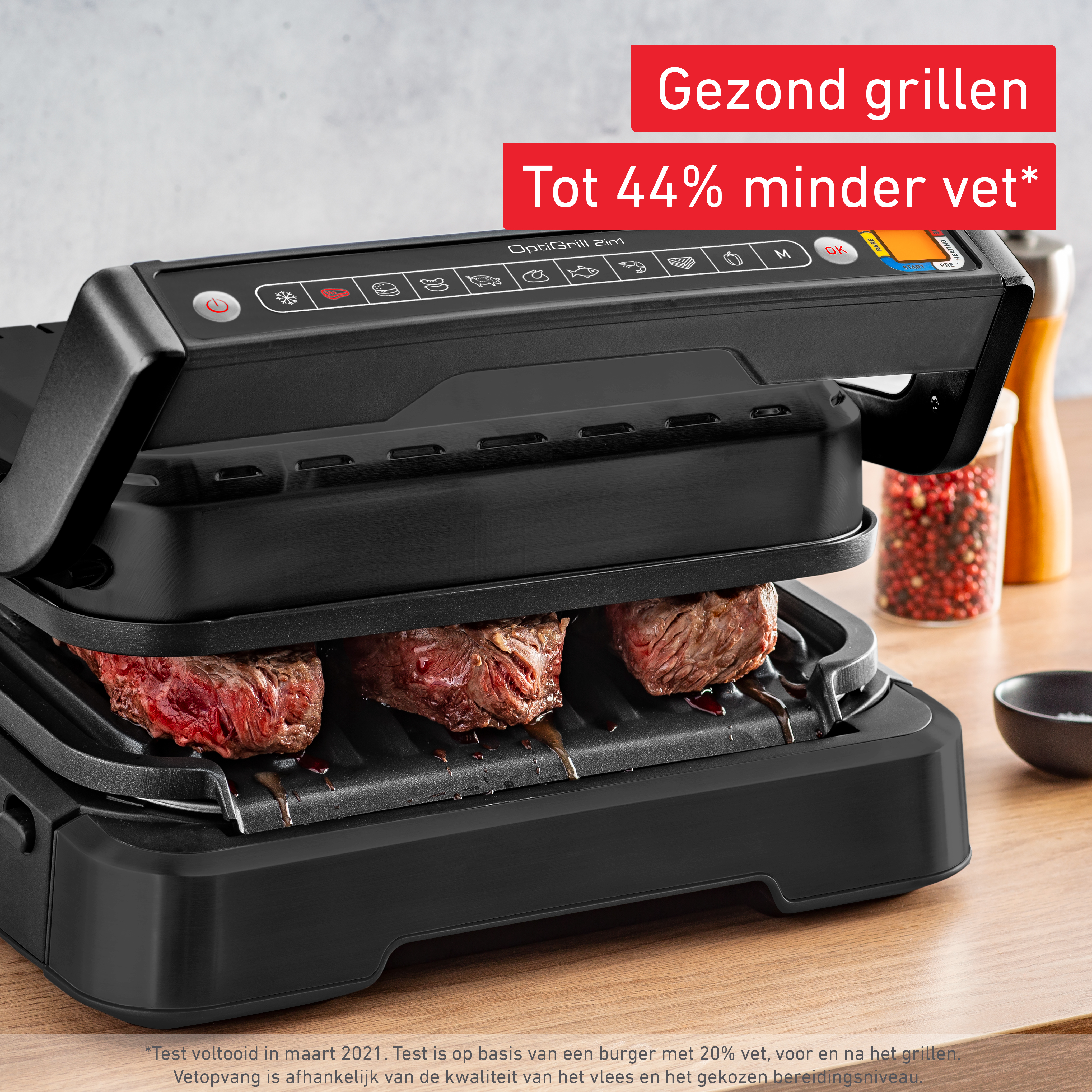 Un Tefal OptiGrill nero con bistecche grigliate. Il coperchio è aperto, mostrando la superficie di cottura.