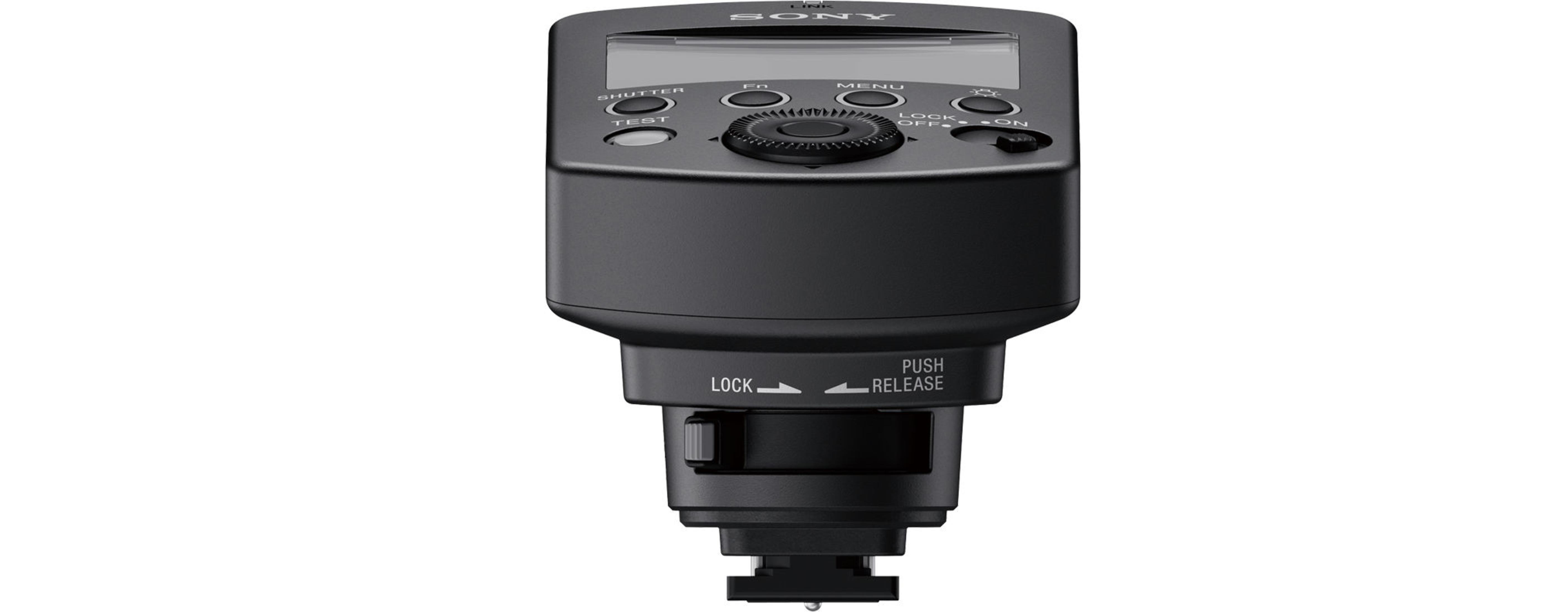 Czarny flash Sony. Posiada wyświetlacz, przyciski funkcyjne i mechanizm blokujący.