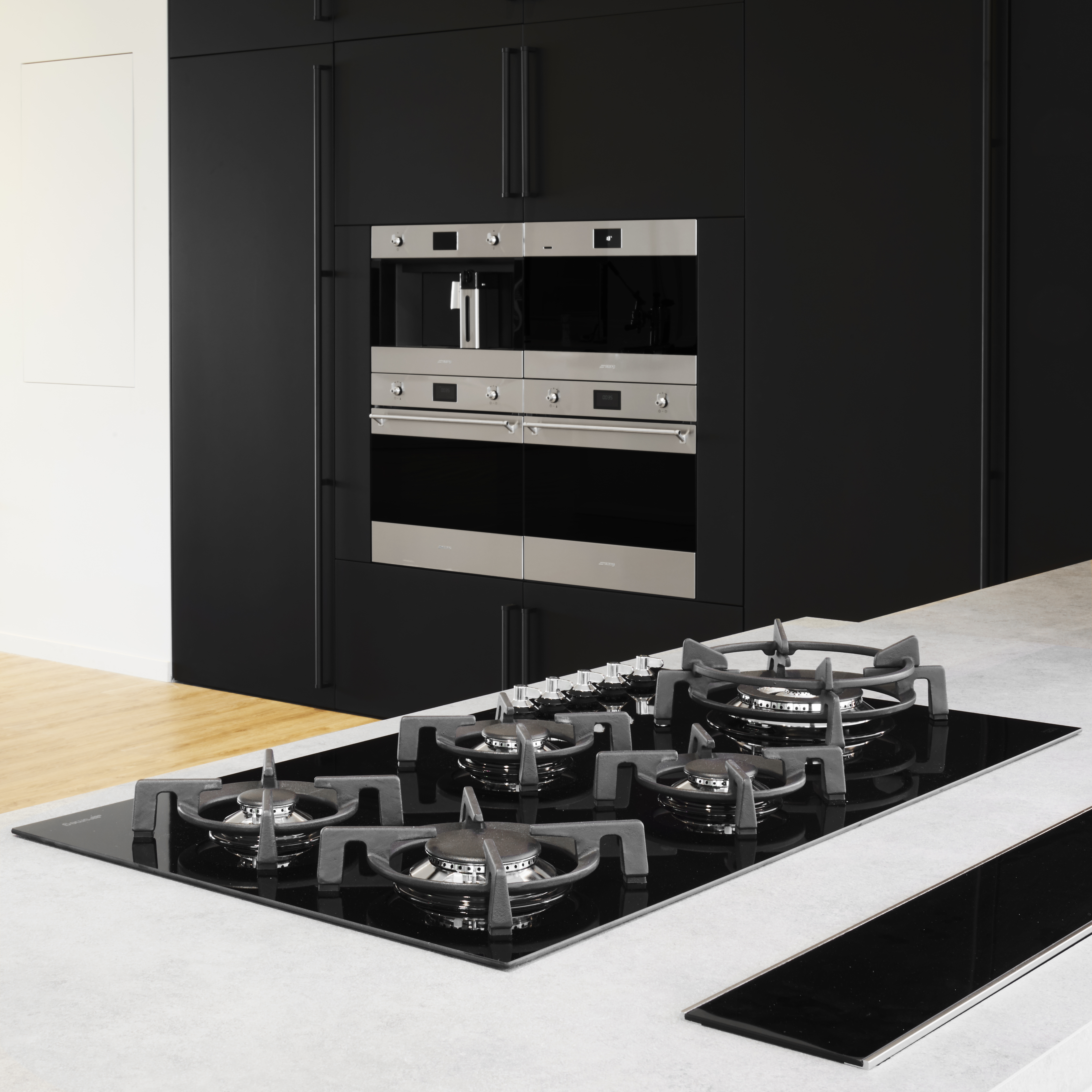 Una moderna cucina nera con forno a incasso e piano cottura a gas.