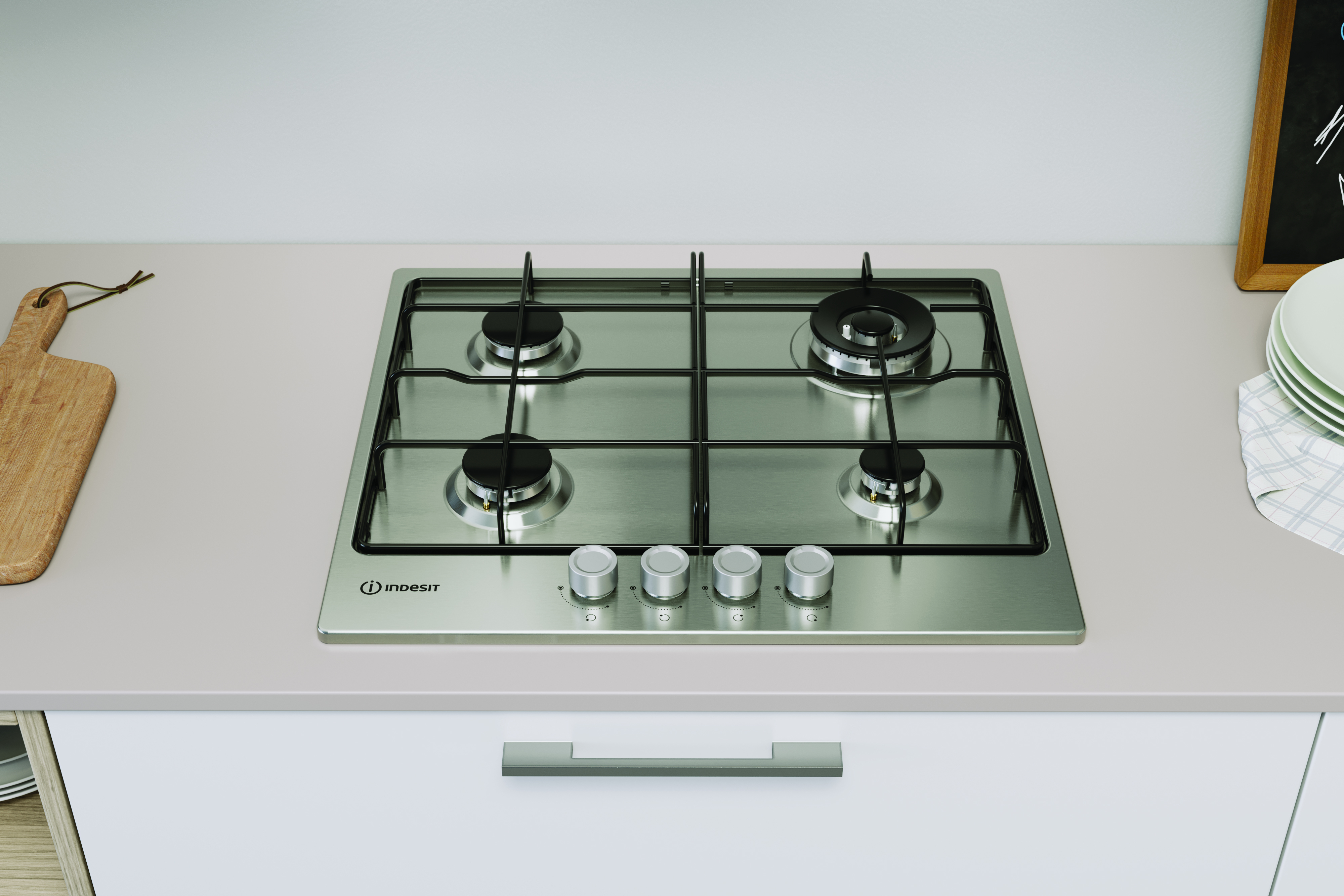 Płyta gazowa ze stali nierdzewnej z czterema palnikami i srebrnymi pokrętłami. Marka Indesit. W kuchni.