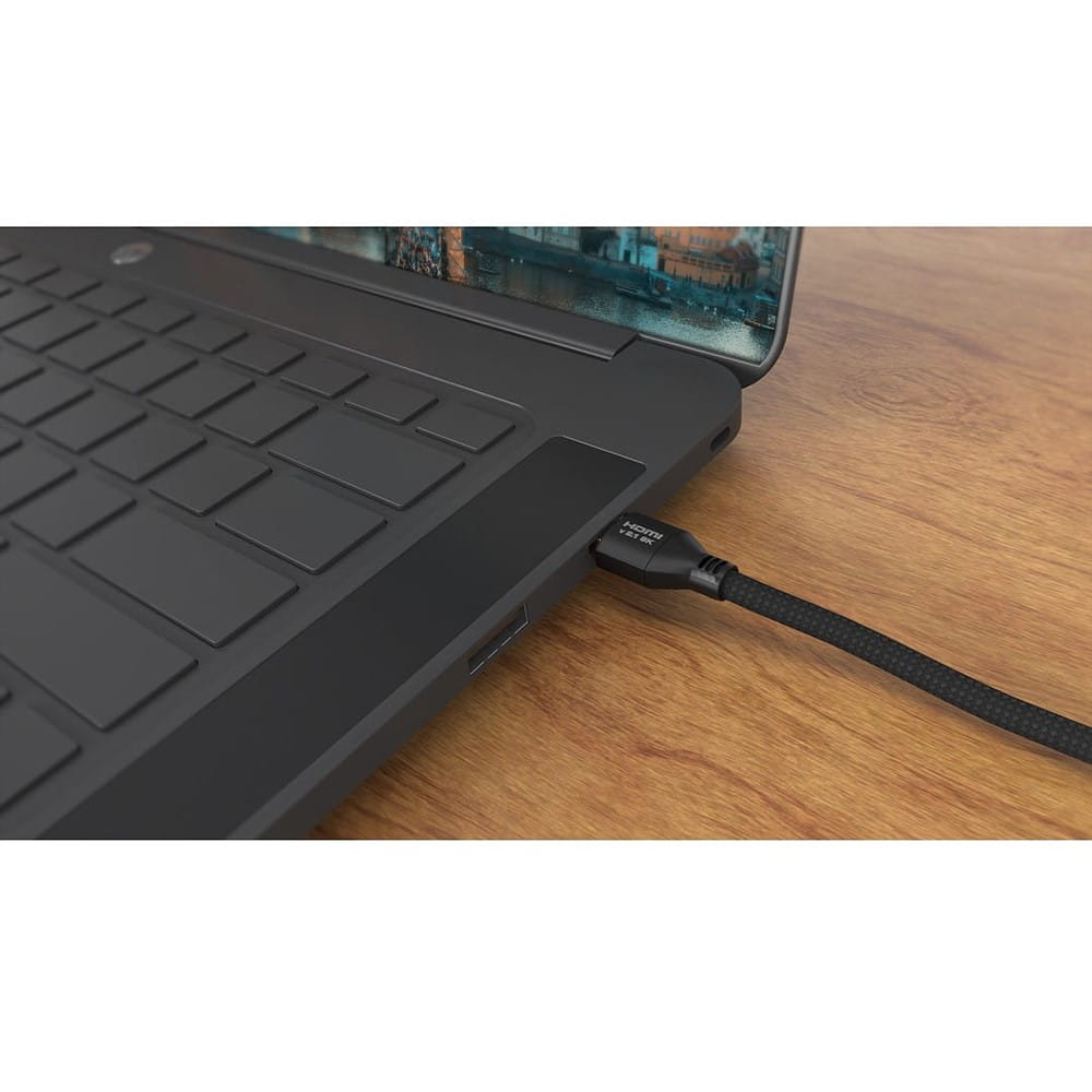 Zbliżenie czarnego laptopa z podłączonym kablem HDMI, spoczywającego na drewnianej powierzchni.