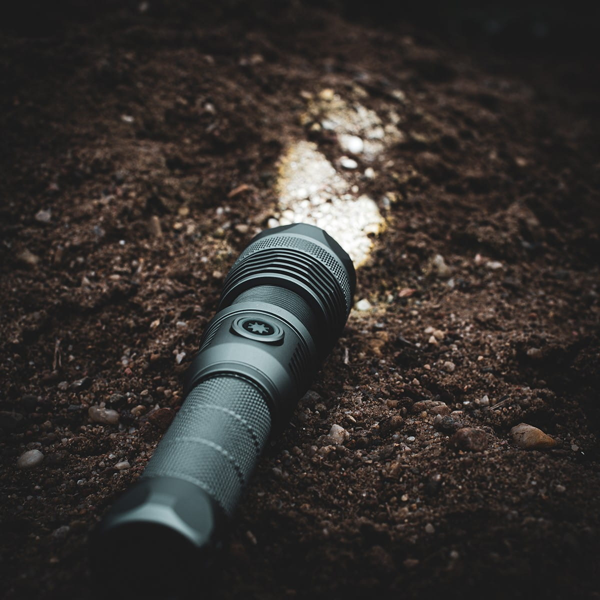 Latarka świecąca na ziemi, oświetlająca ścieżkę w ciemności.