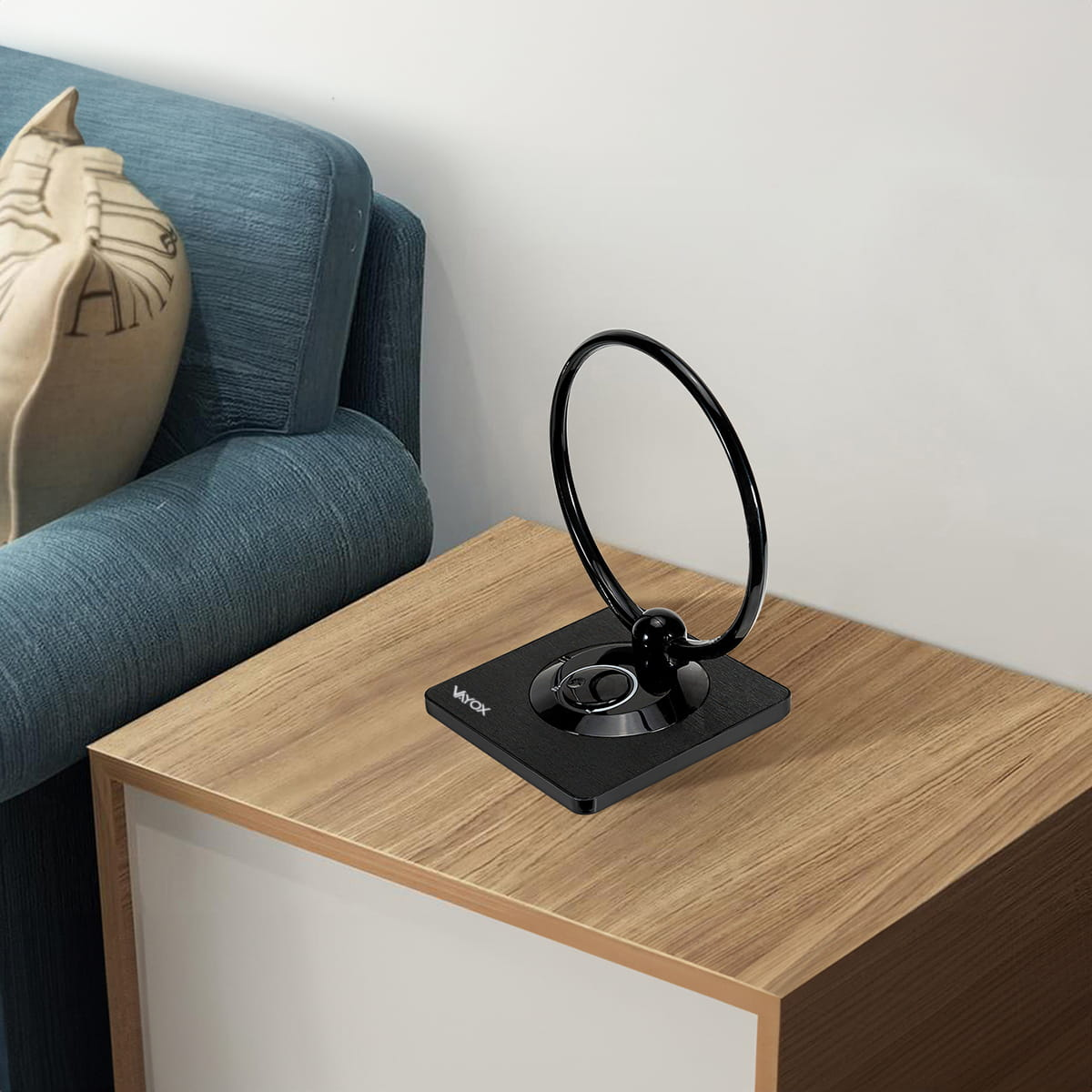 Czarna antena TV na drewnianej szafce nocnej. W tle niebieska kanapa.