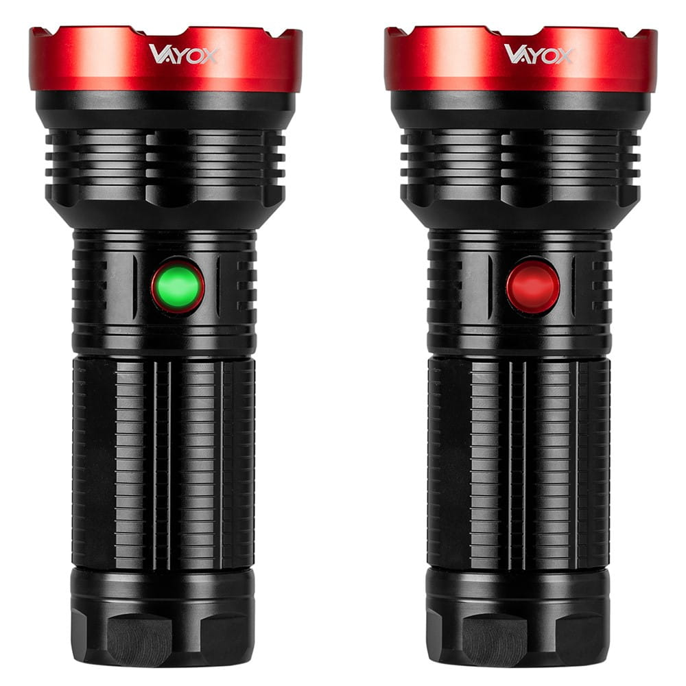 Dwie czarne latarki z czerwonymi pierścieniami i zielonym lub czerwonym przyciskiem. Obok siebie.