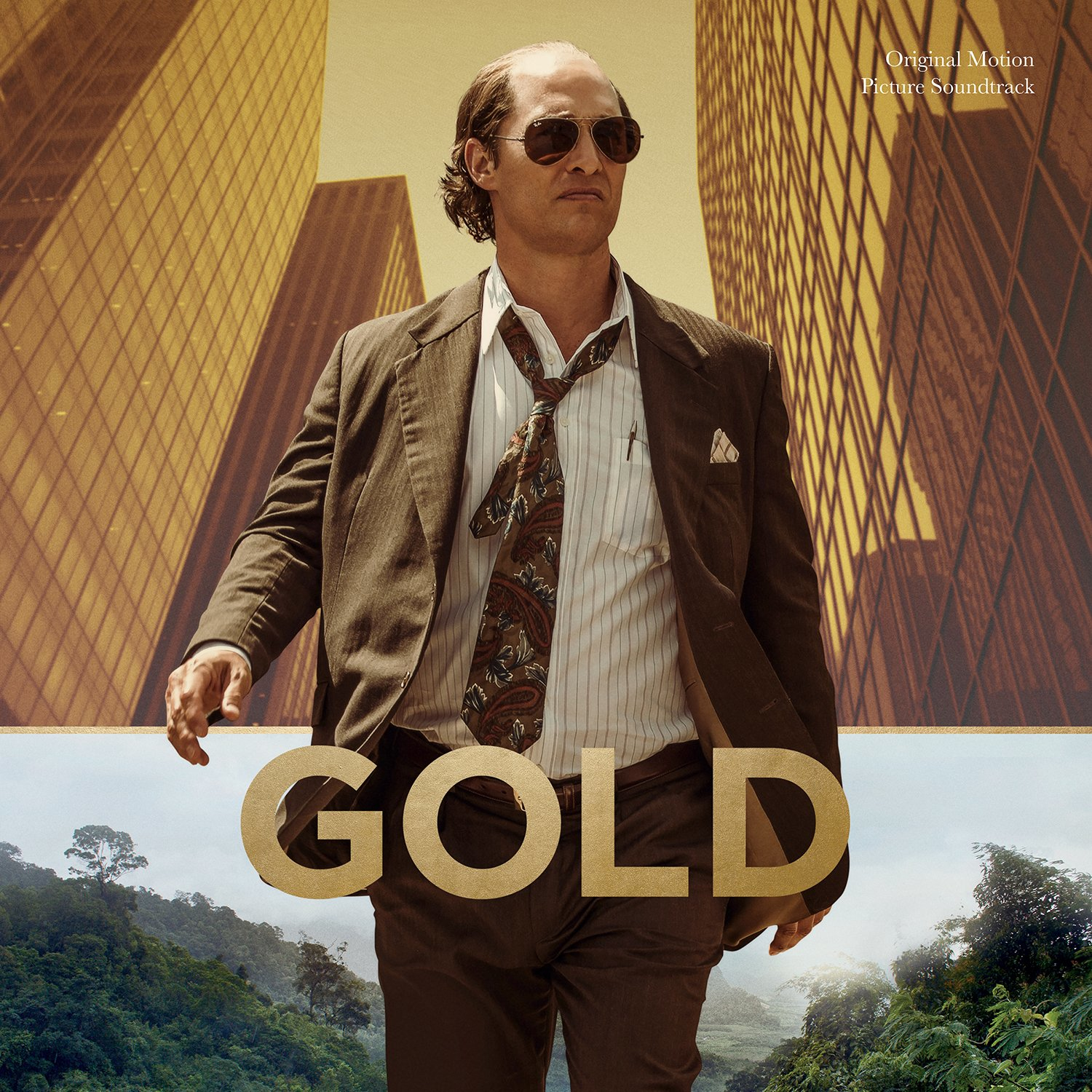Plakat filmowy Gold, Matthew McConaughey w garniturze, okularach przeciwsłonecznych, tło złotych budynków.