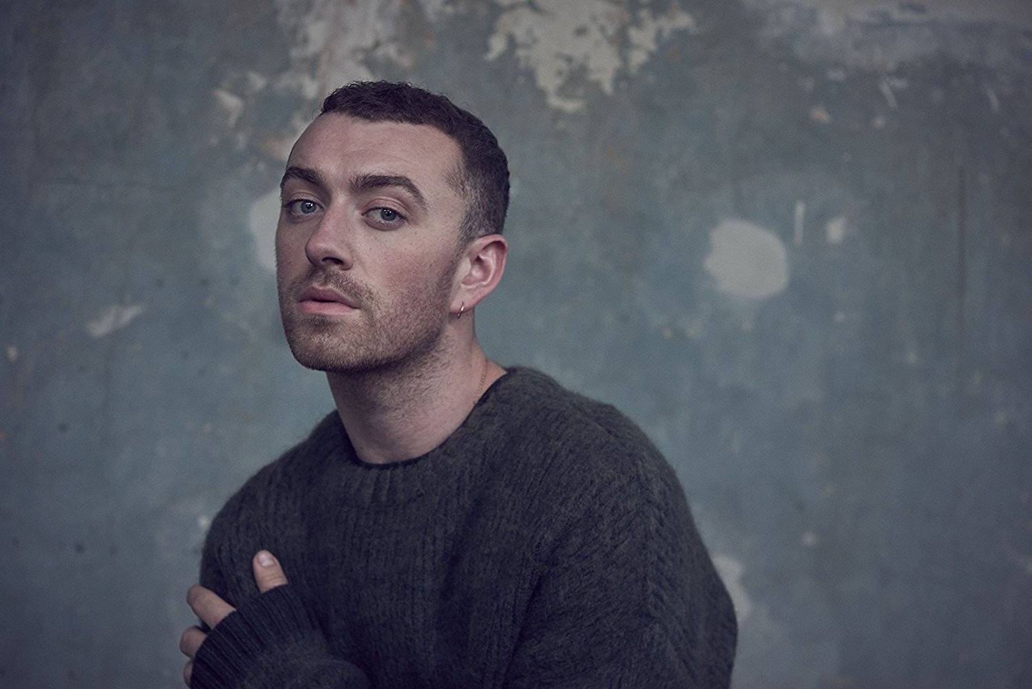 Sam Smith, ritratto, guarda la fotocamera, indossa un maglione verde scuro.