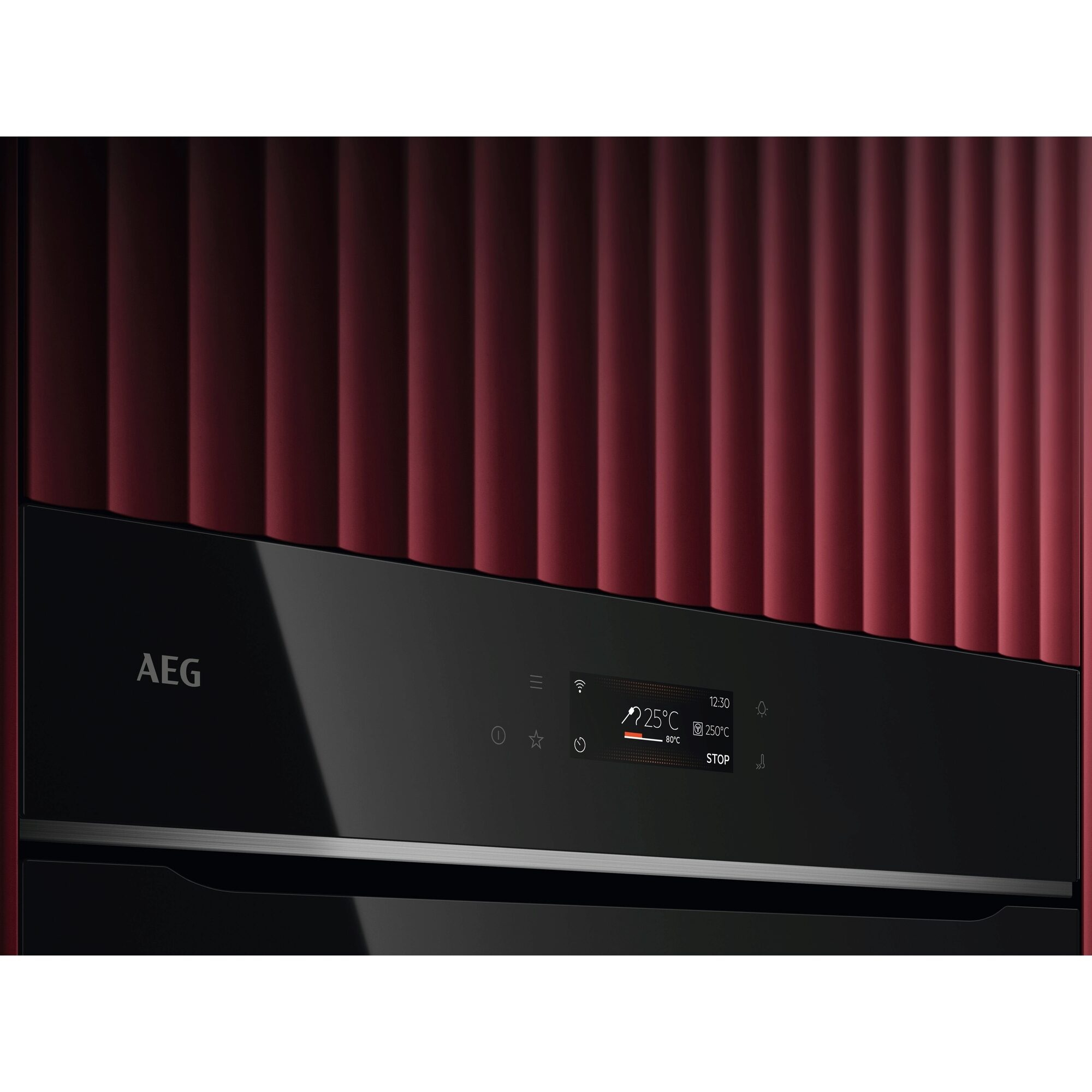 Czarny front piekarnika AEG z cyfrowym wyświetlaczem na tle czerwonej, żebrowanej ściany.
