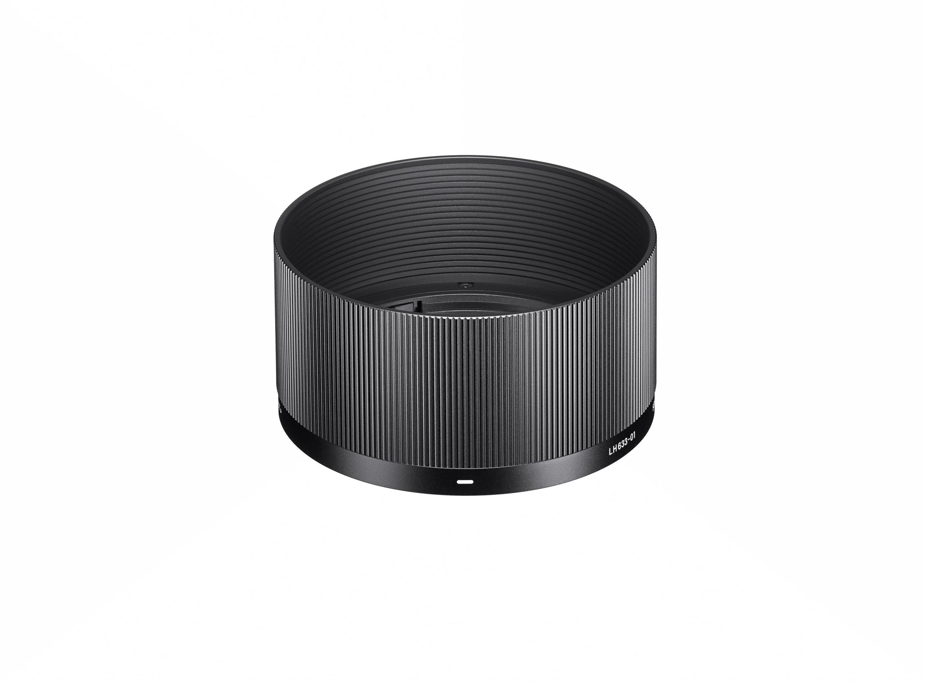 Czarna osłona przeciwsłoneczna z pionowymi rowkami. Okrągły kształt. Leży na białym tle.