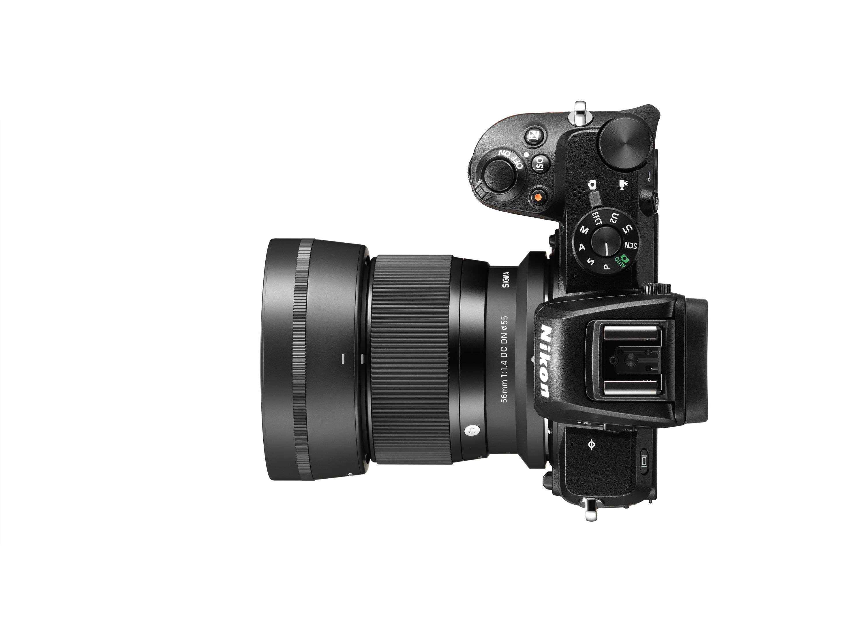 Aparat z dołączonym obiektywem, widok z góry na białym tle.