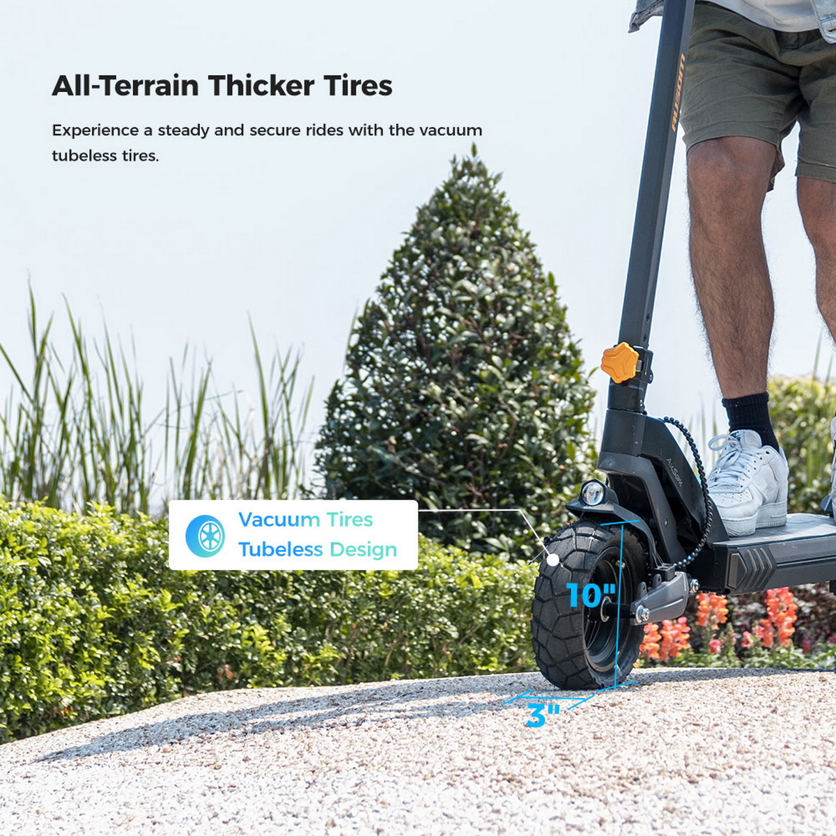 Hulajnoga elektryczna z grubymi oponami na żwirowej nawierzchni. W tle krzew i trawa.