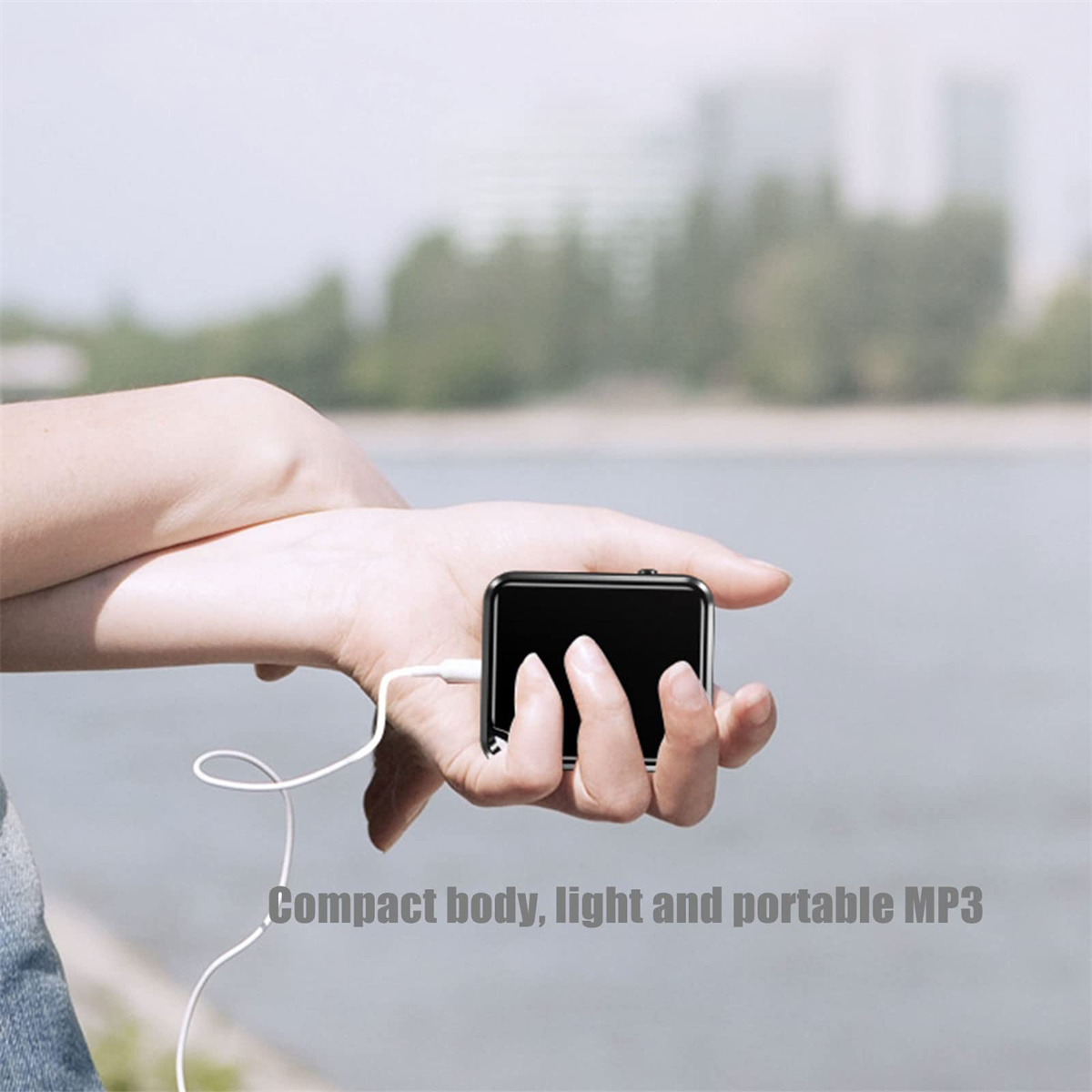 Eine Person hält einen kleinen, schwarzen MP3-Player mit weißen Ohrhörern.