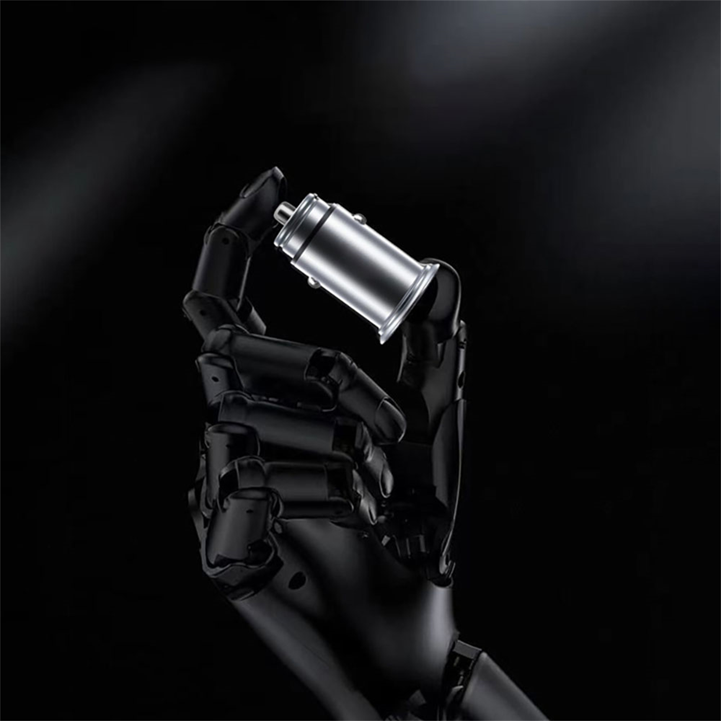 Eine schwarze Roboterhand, die ein silbernes zylindrisches Autoladegerät hält.