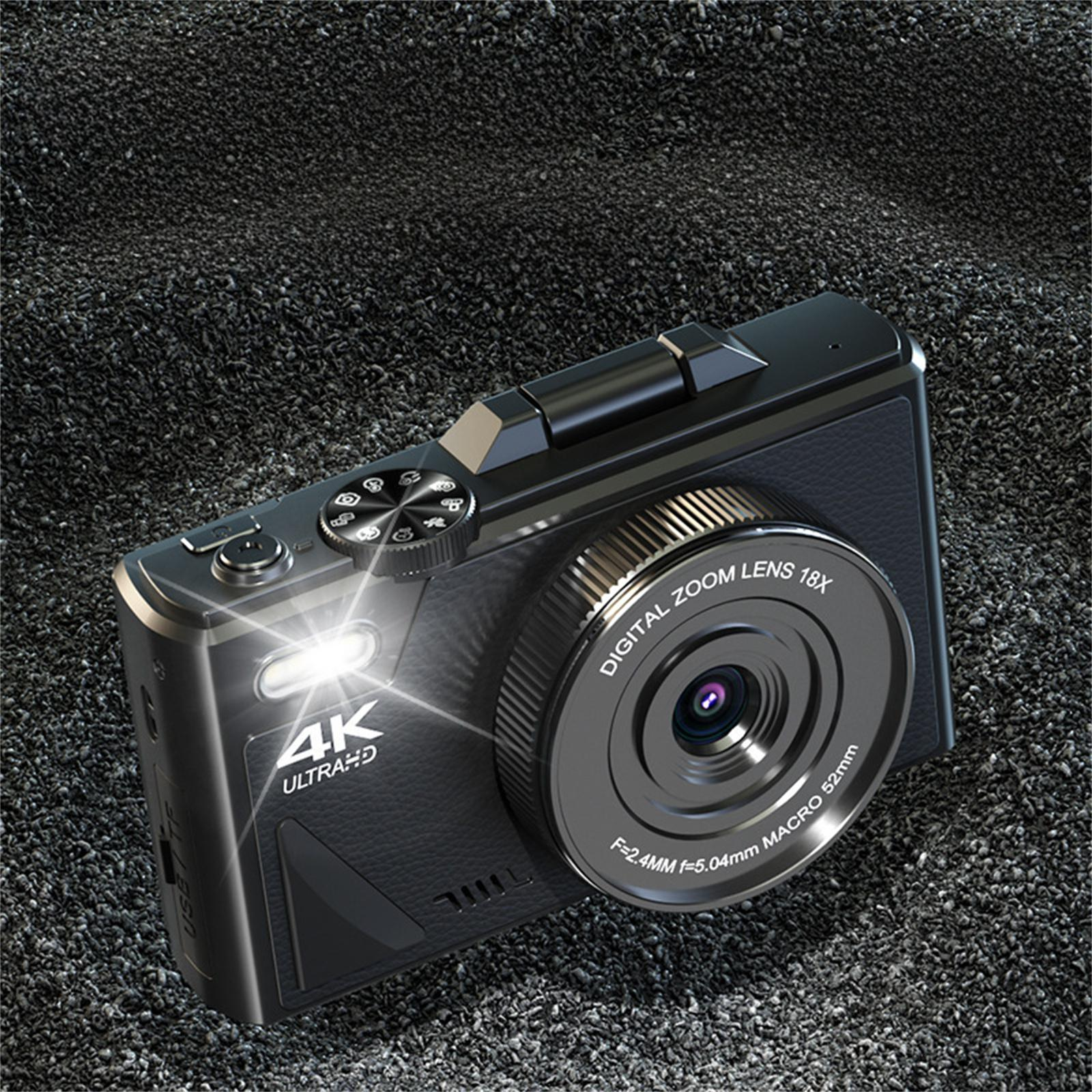Eine schwarze Kamera auf einer dunklen Oberfläche. Die Kamera hat ein Objektiv und einen Blitz. Der Hintergrund ist eine dunkle Oberfläche.