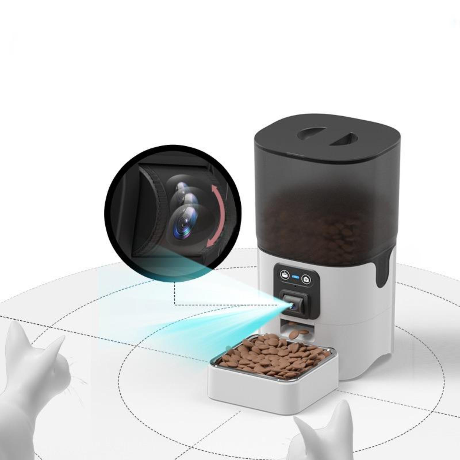Automatischer Futterautomat mit Kamera, gibt Futter in eine Schüssel. Zwei weiße Katzenfiguren.