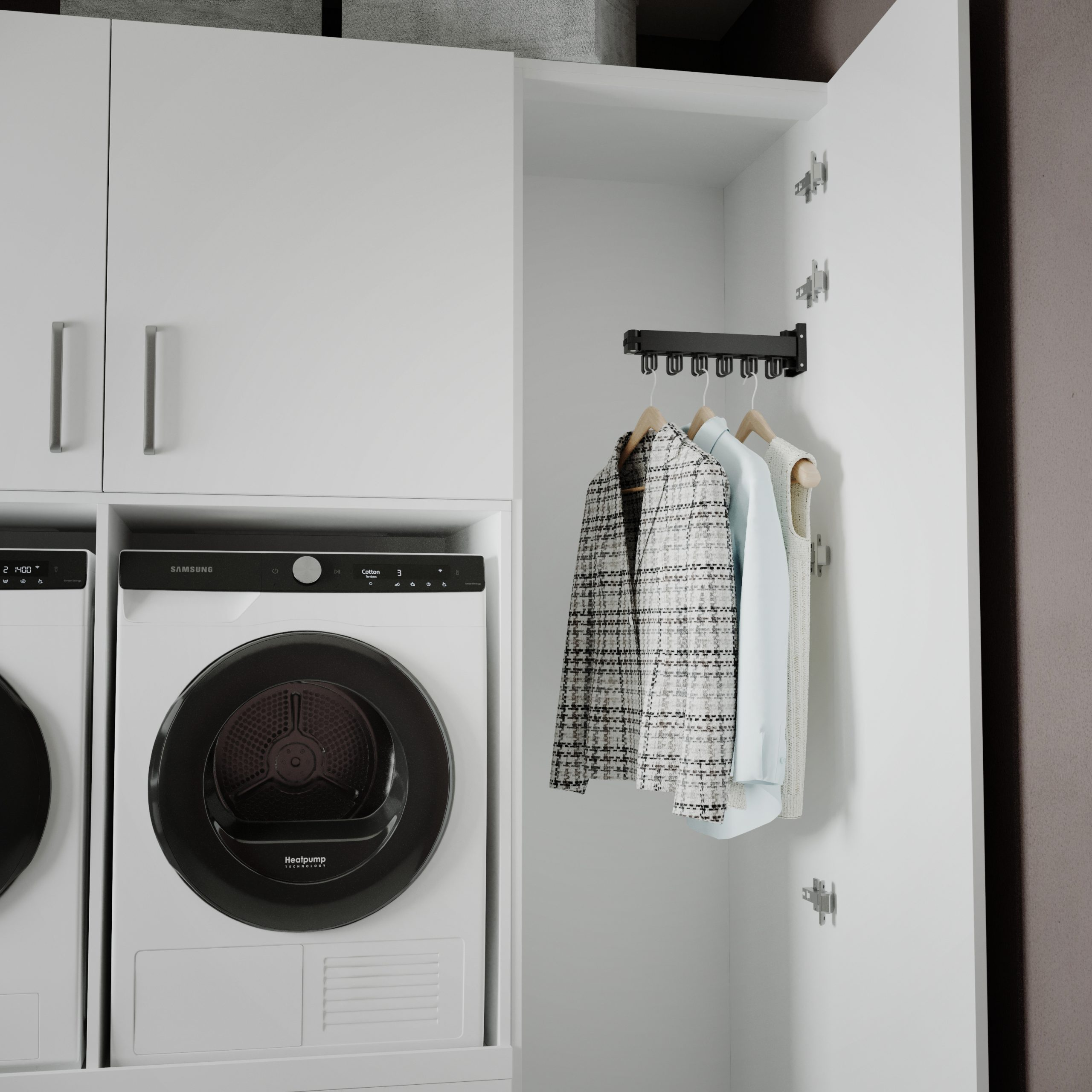 Une buanderie avec un sèche-linge blanc, des placards et des vêtements suspendus. Une porte est ouverte, révélant les vêtements.