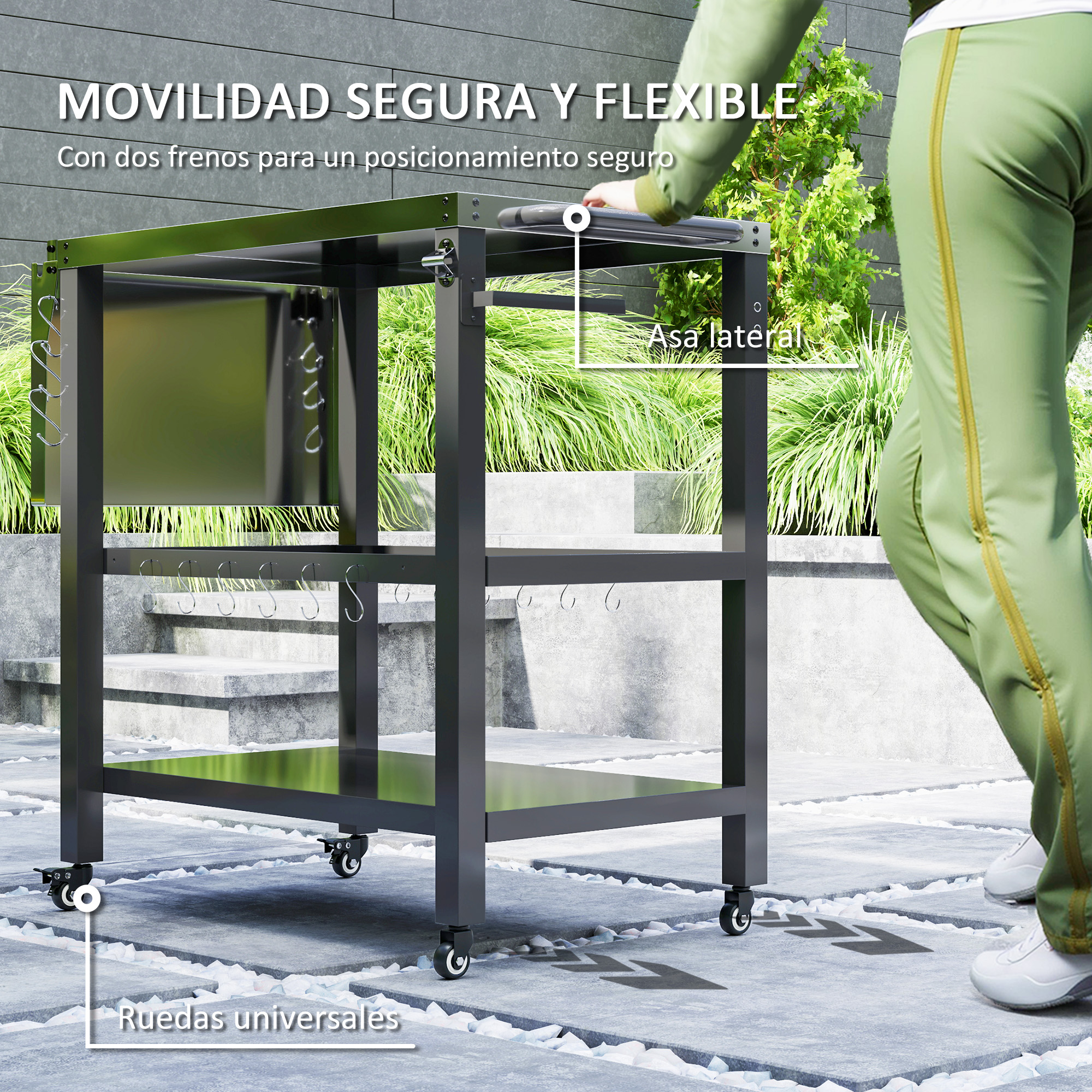 Una persona con pantalones verdes empuja un carro de cocina exterior negro.