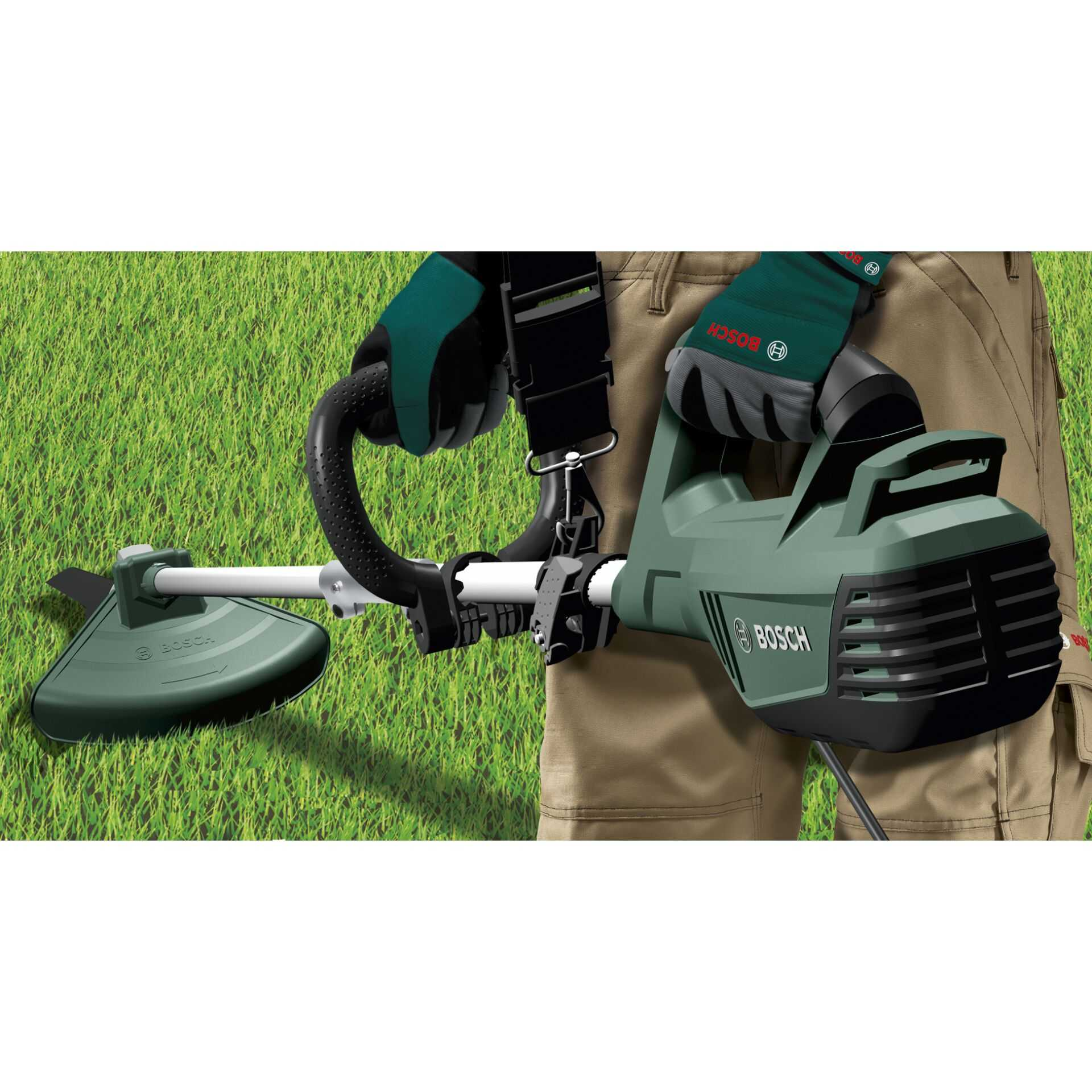 Eine Person mit Handschuhen hält einen grünen und schwarzen Rasentrimmer vor grünem Gras.