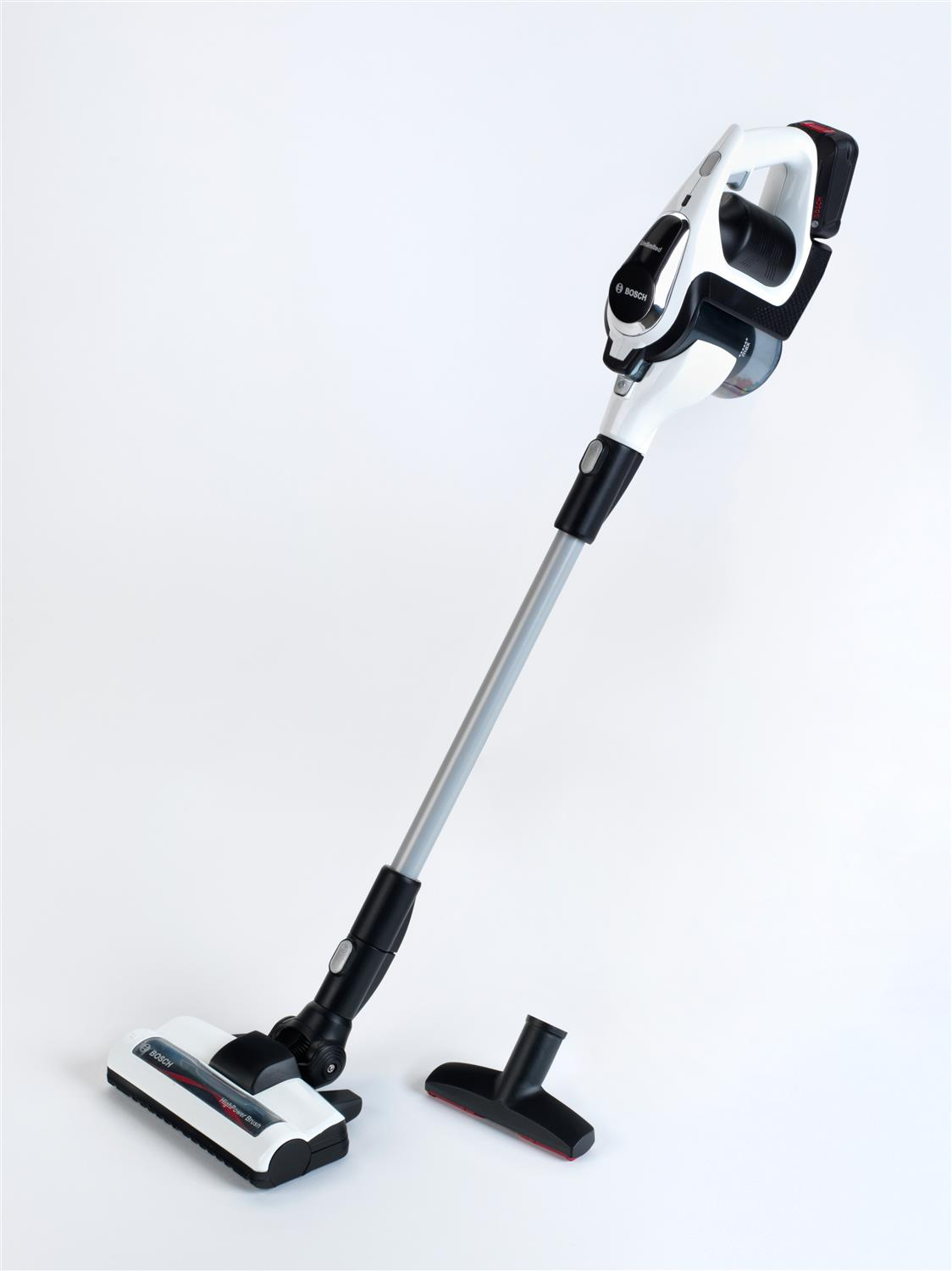 Biało-czarny bezprzewodowy odkurzacz Bosch z akcesoriami na białej powierzchni.