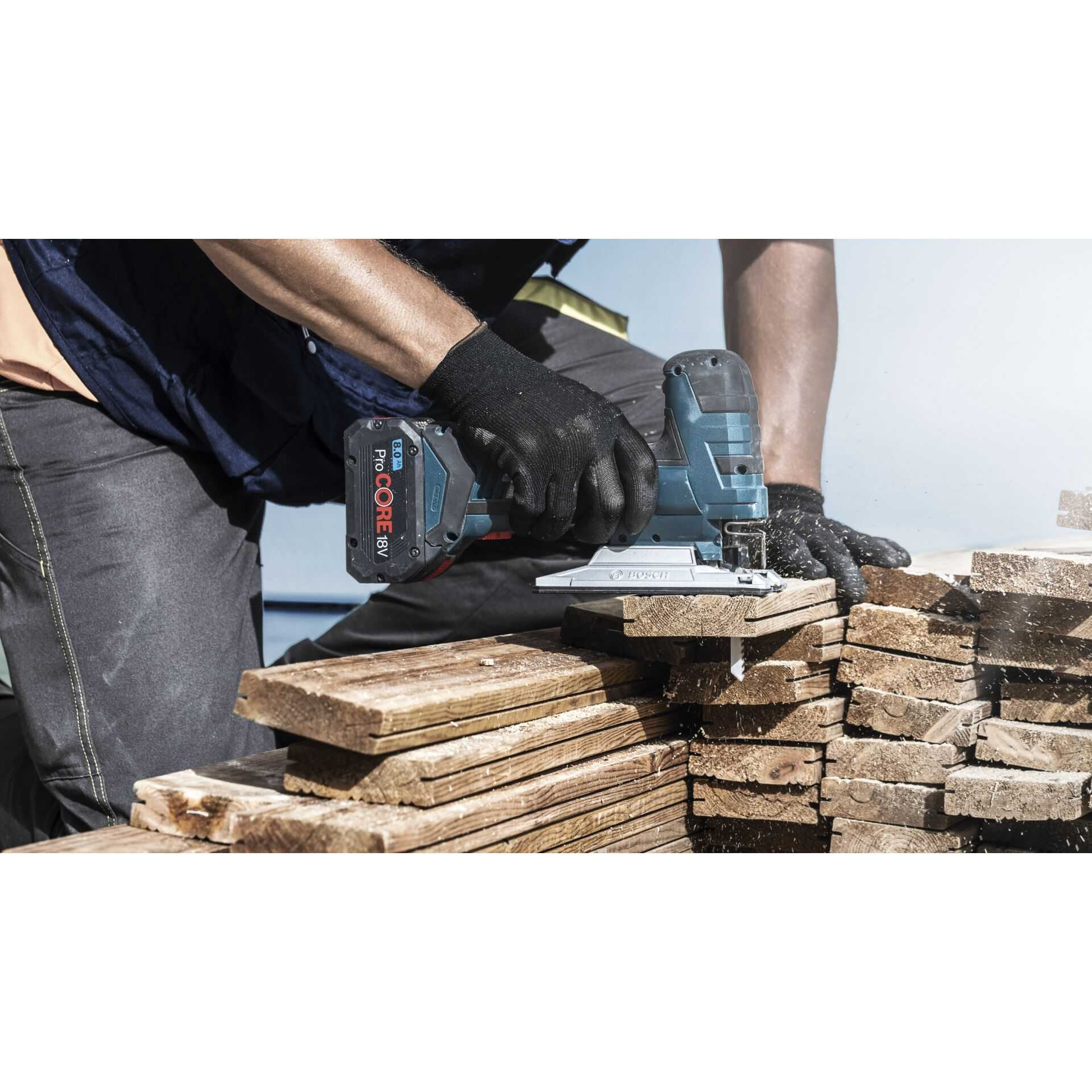 Niebiesko-czarna wyrzynarka Bosch tnąca drewniane deski.