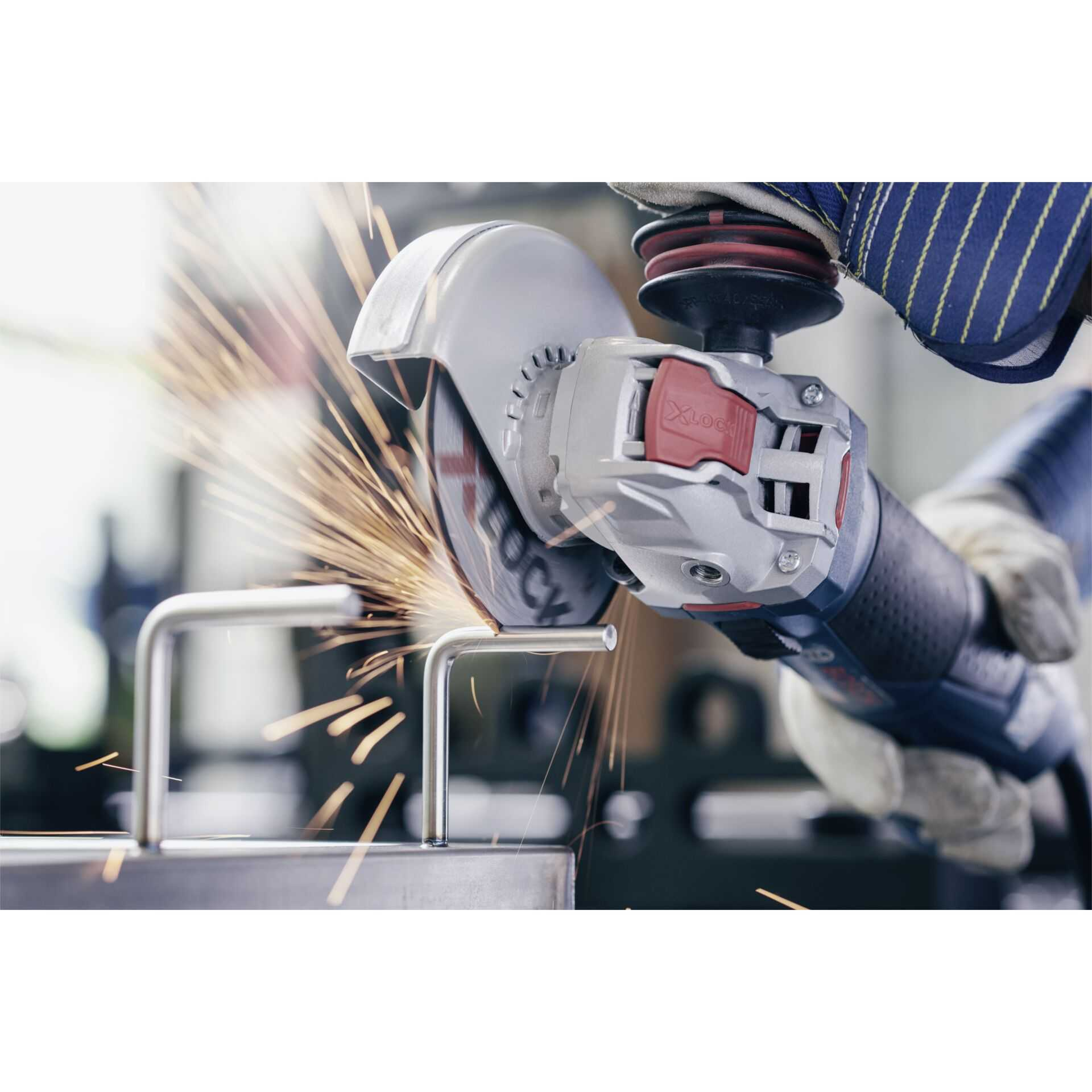 Een haakse slijper in actie, vonken vliegen. Een metalen staaf wordt gesneden. Een persoon houdt de slijper vast.