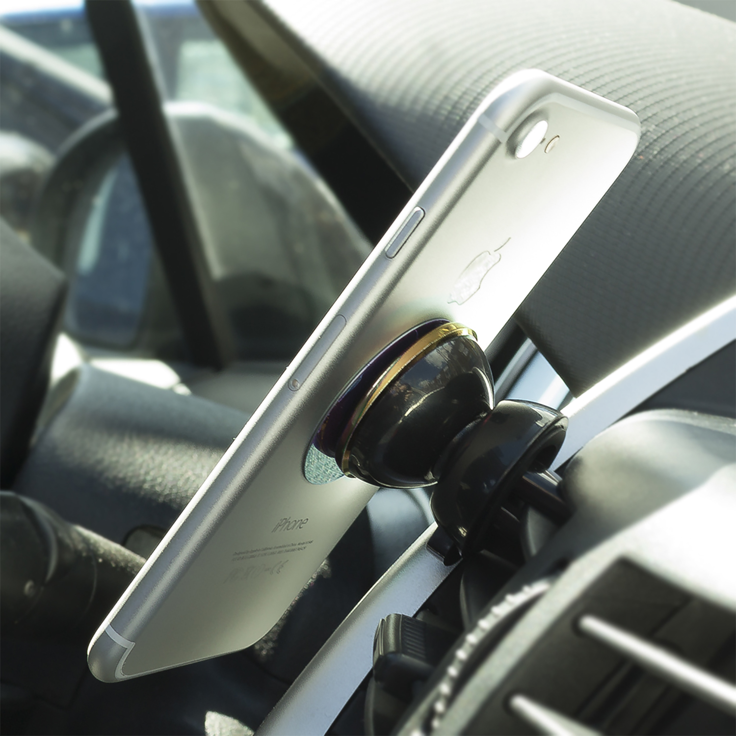 Telefono montato su un supporto in auto, nero e oro, con riflesso.