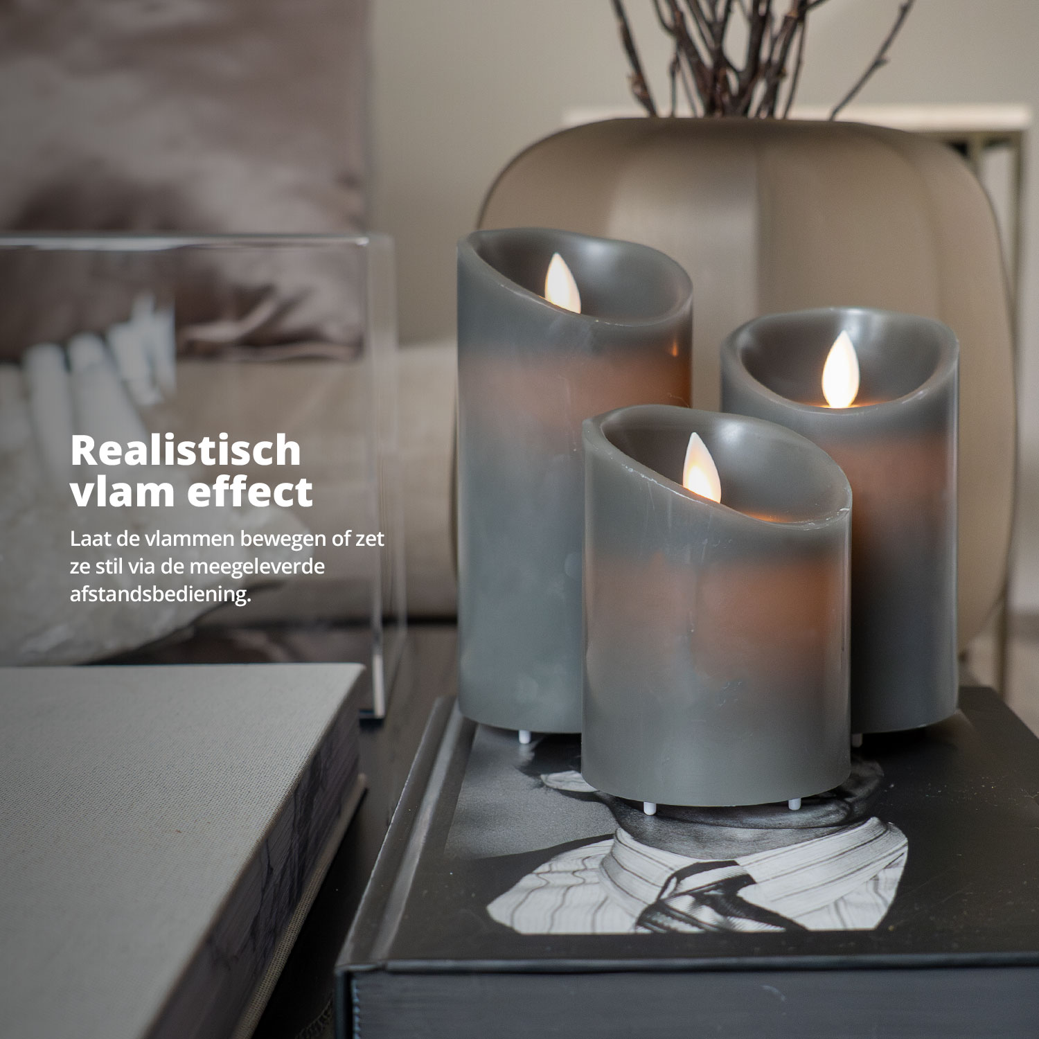 Trois bougies grises avec effet de flamme réaliste sur une table. Vase en arrière-plan.