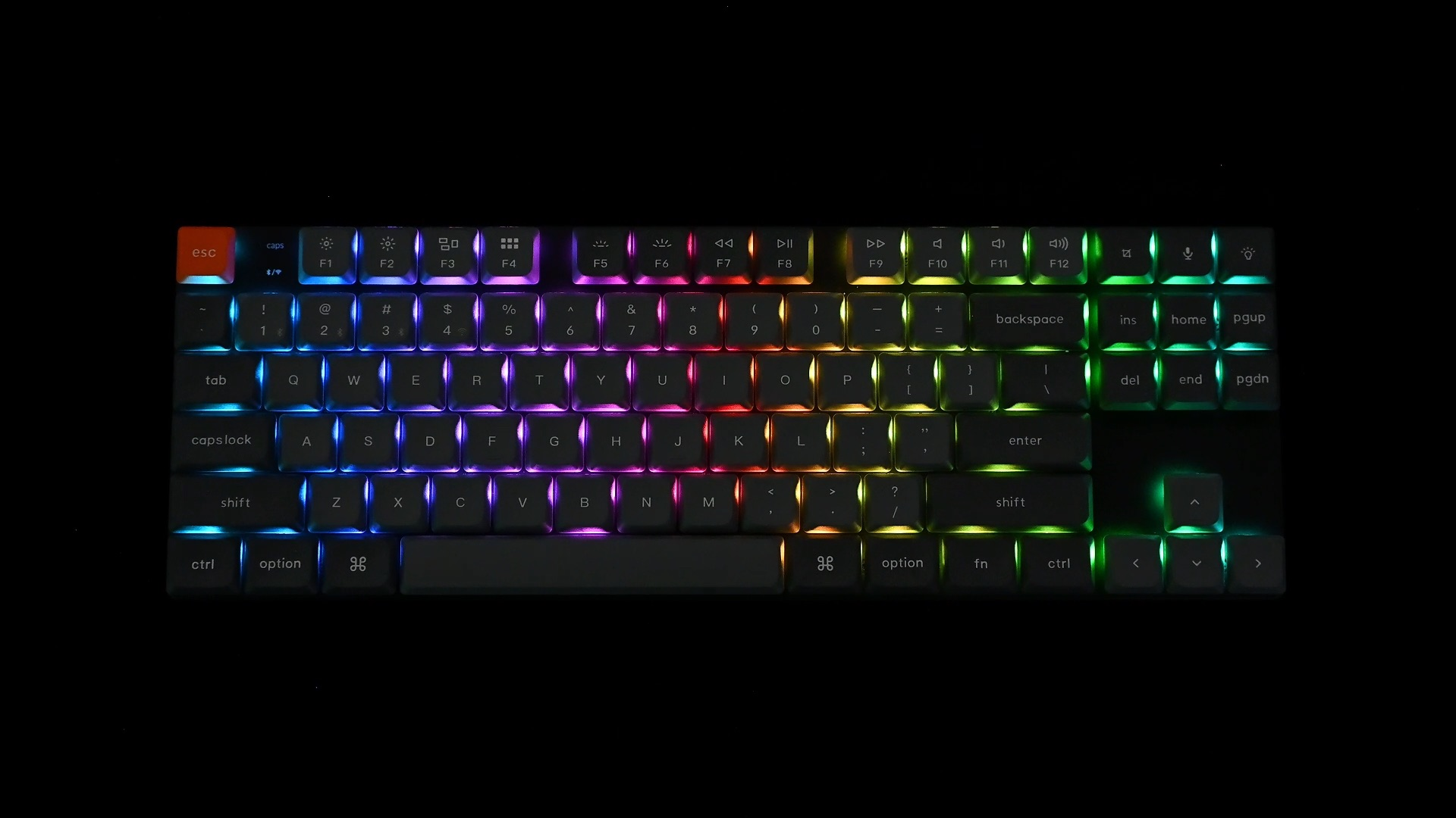 Czarna klawiatura z kolorowymi światłami na ciemnym tle.