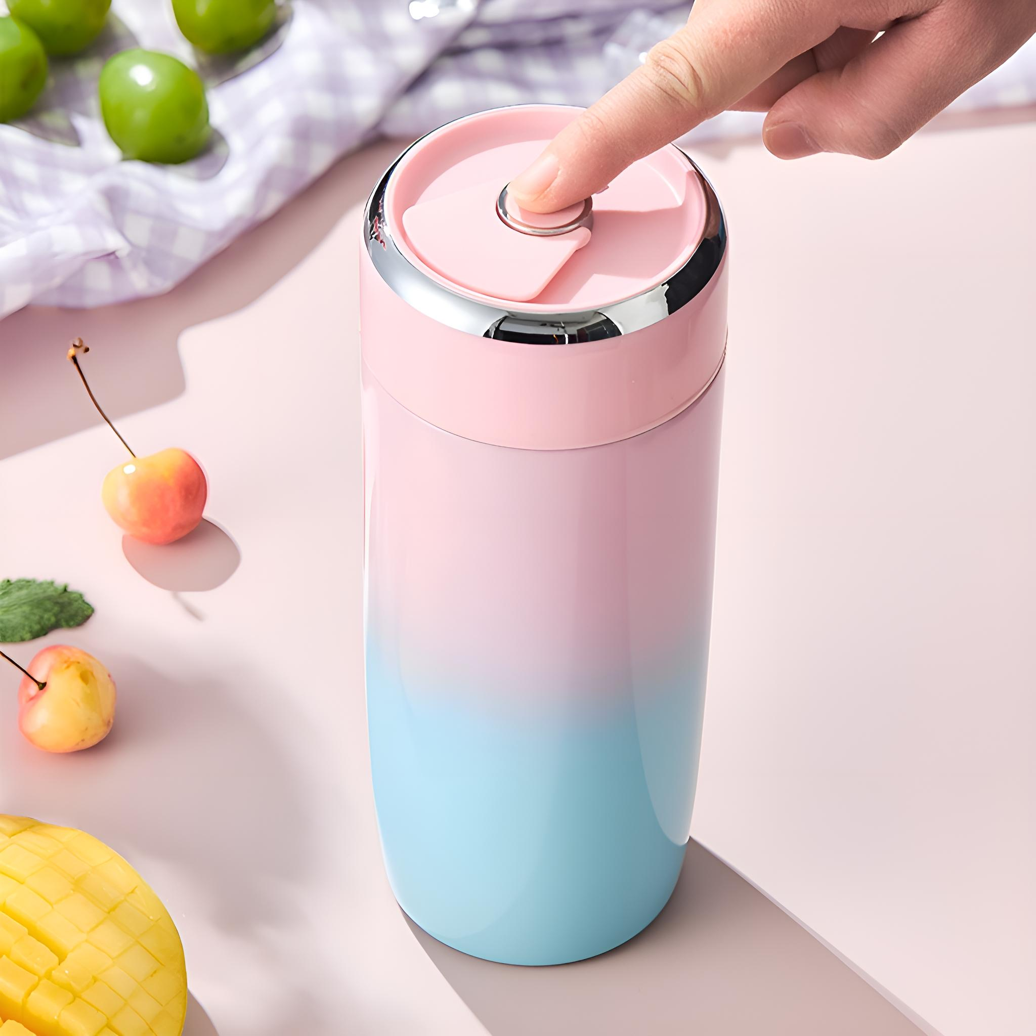 Ein rosa-blauer Farbverlauf-Becher mit silbernem Rand. Ein Finger drückt auf den Deckel.