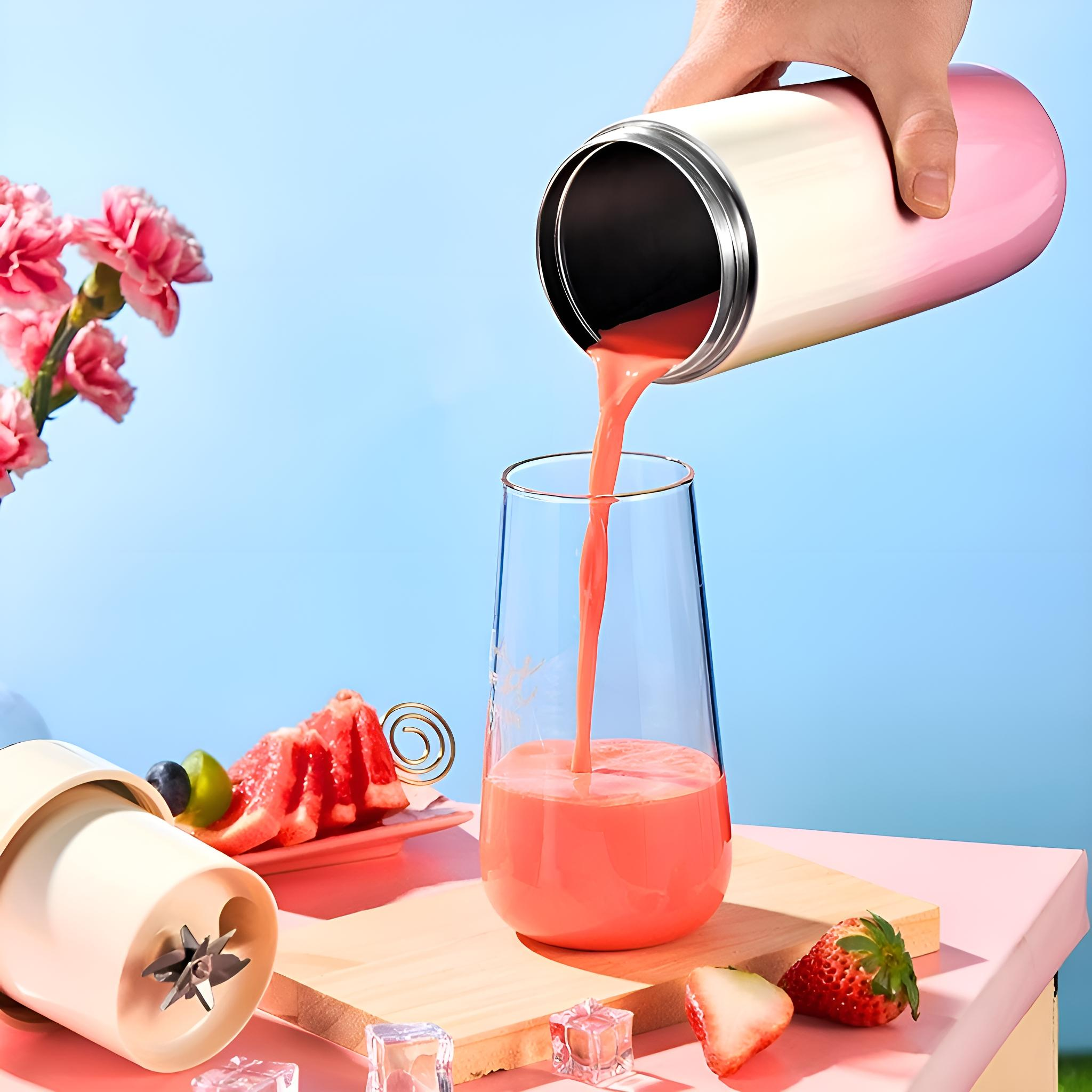 Eine Hand gießt rosa Saft aus einer Flasche in ein Glas mit Obst und Eis.