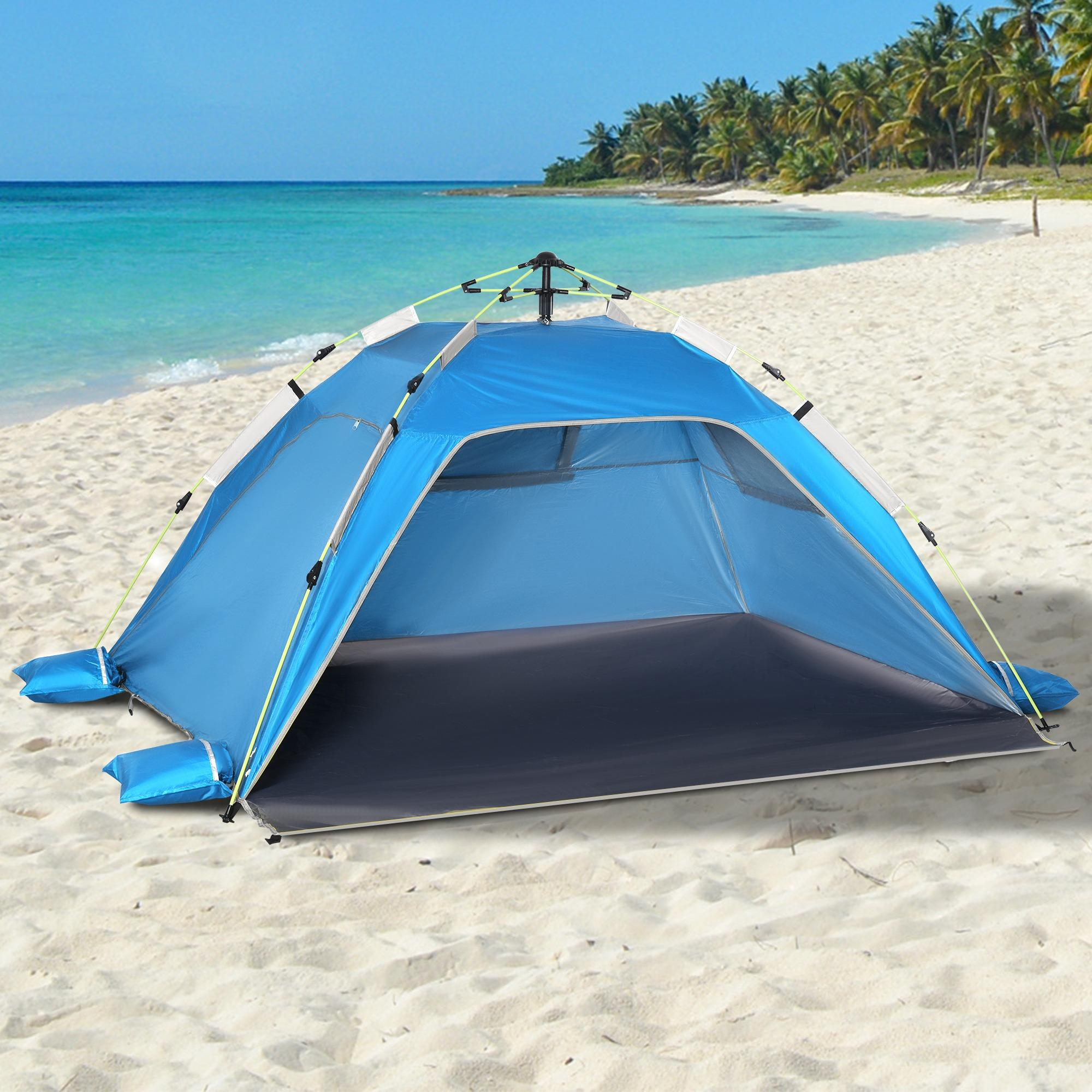 Ein blaues Zelt an einem Sandstrand mit Meer und Palmen im Hintergrund an einem sonnigen Tag.