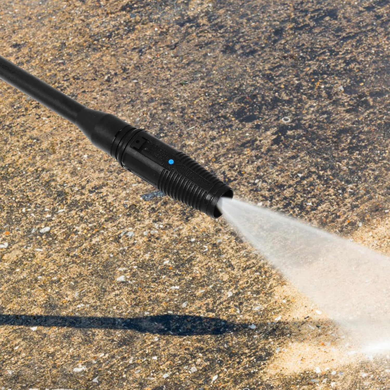 Eine schwarze Hochdruckreinigerdüse, die Wasser auf eine Betonoberfläche sprüht.