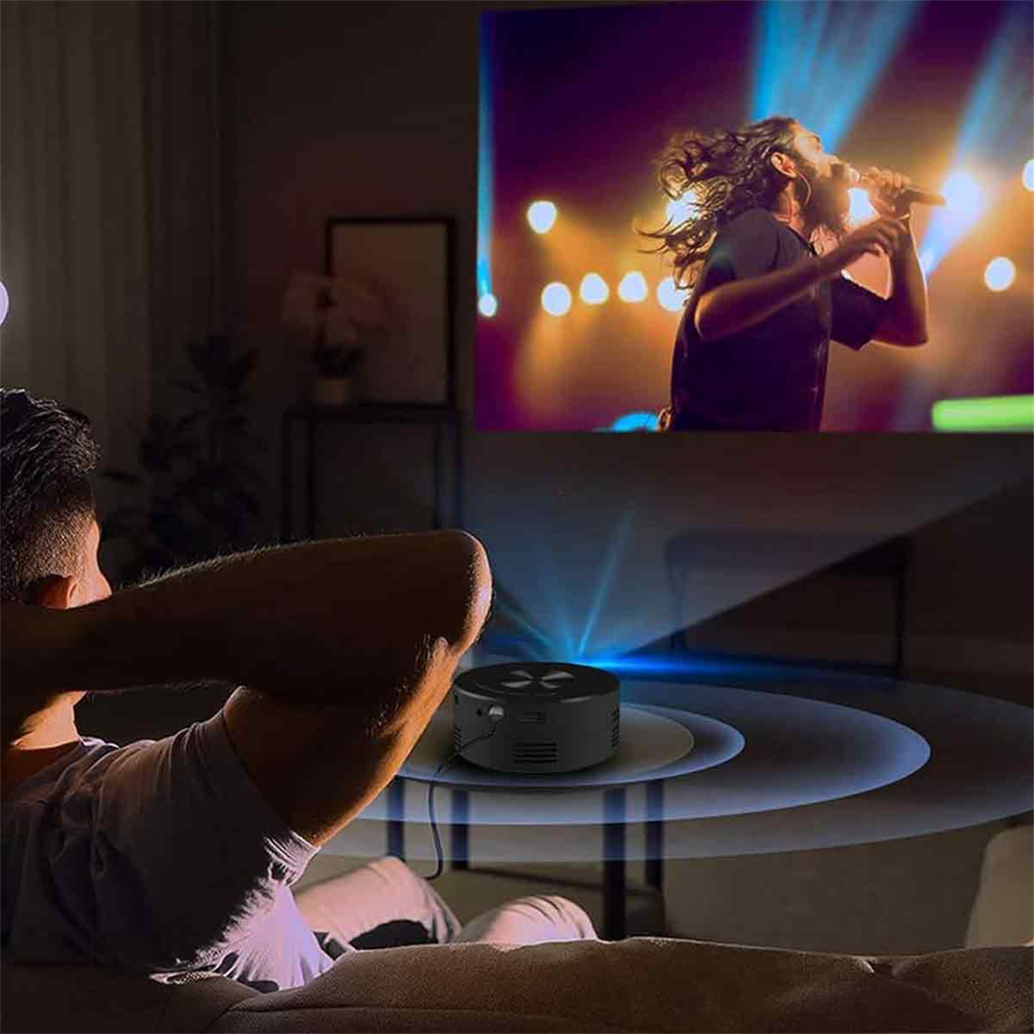 Mann sieht sich eine Live-Performance auf einem Bildschirm an. Projektor auf dem Tisch. Dunkler Raum. Weißer Hintergrund.