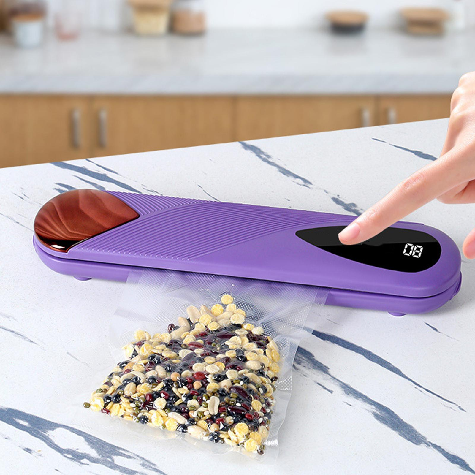 Eine Person drückt einen Knopf auf einem violetten Vakuumiergerät. Ein Beutel mit Lebensmitteln wird versiegelt.