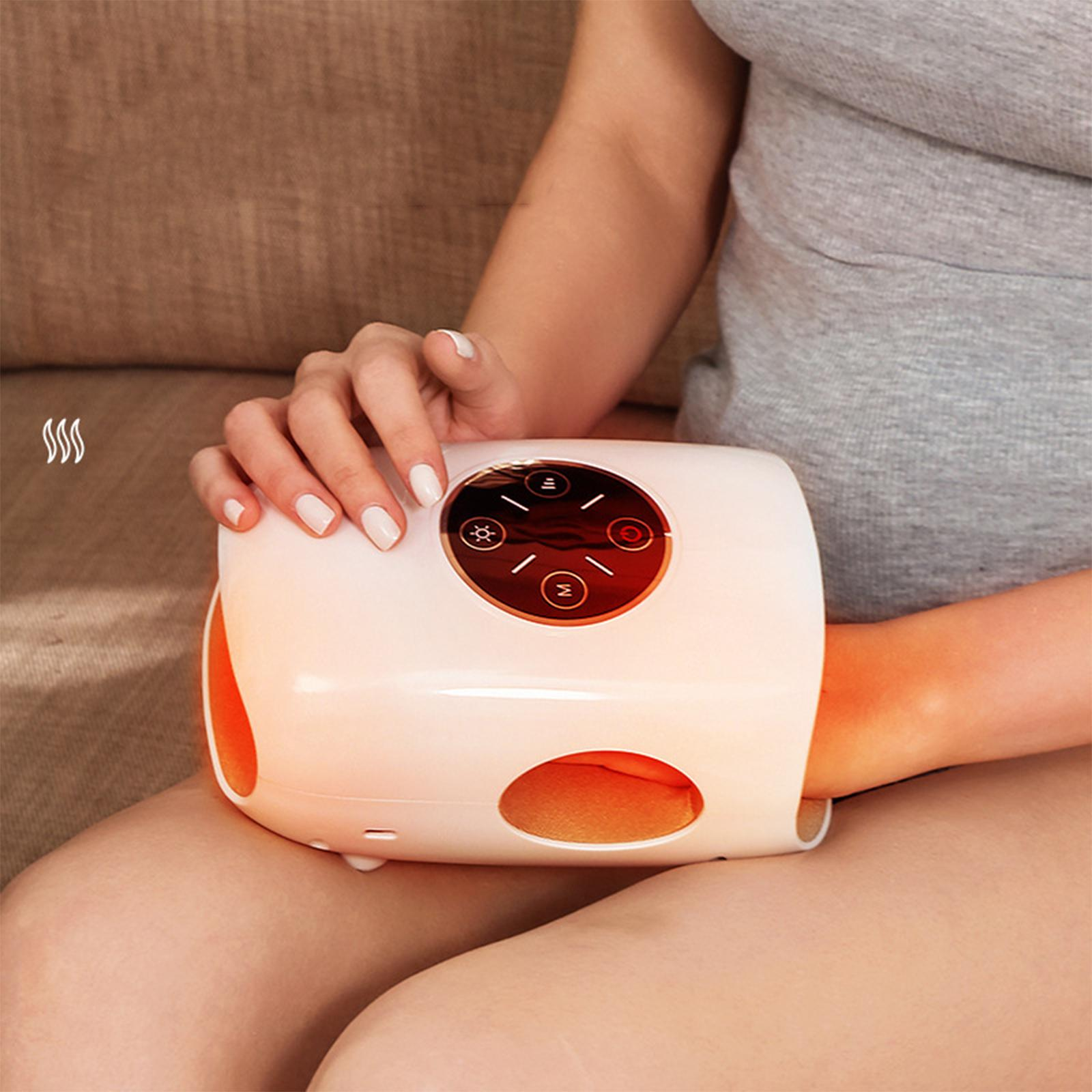 Ein weißes Handmassagegerät, das eine Frau hält. Braunes Sofa und Haut. Weißer Nagellack.