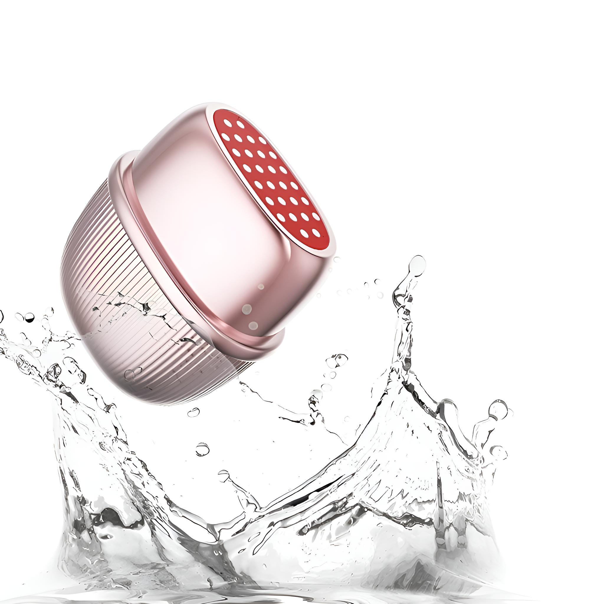 Ein roségoldener Duschkopf mit roter, gepunkteter Basis, umgeben von Wasserspritzern auf weißem Hintergrund.