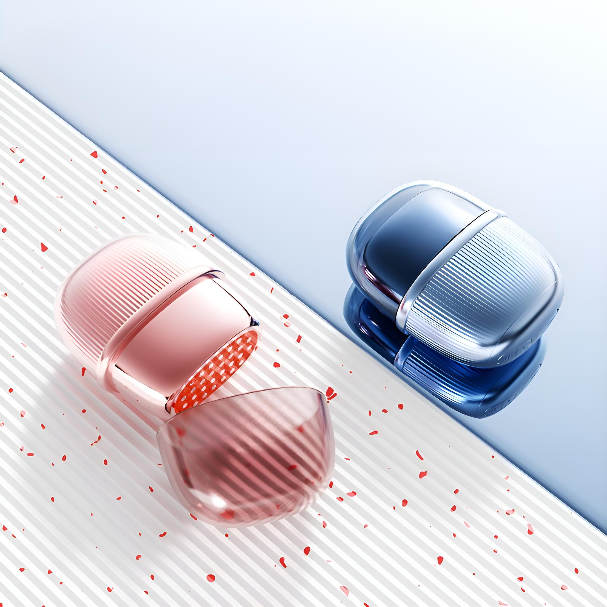 Zwei kapselförmige Objekte, eines offen, auf einer diagonalen Oberfläche mit rotem Konfetti. Eines rosa, das andere blau.