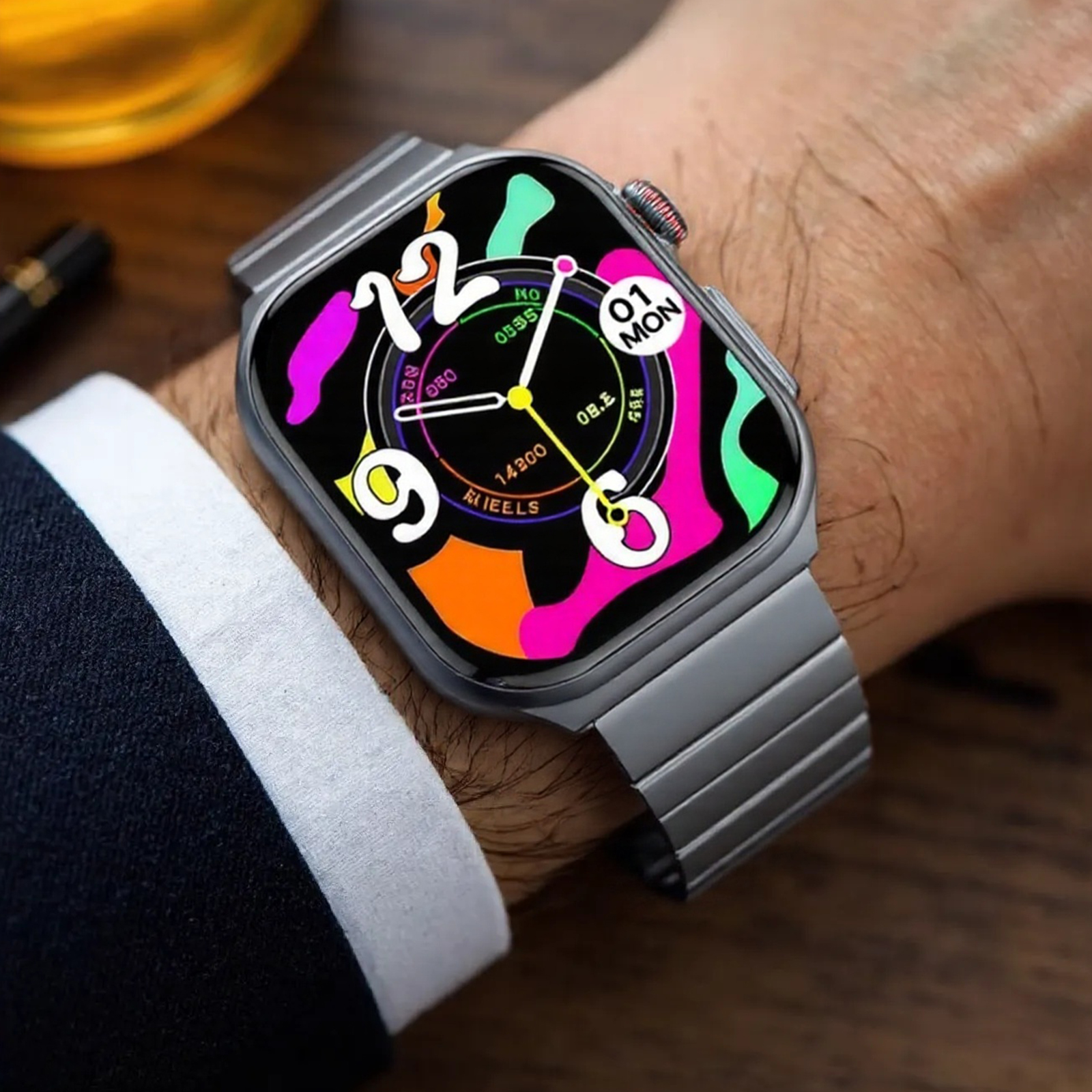 Das Handgelenk einer Person mit einer Smartwatch. Die Uhr hat ein graues Metallarmband und ein farbenfrohes Display.