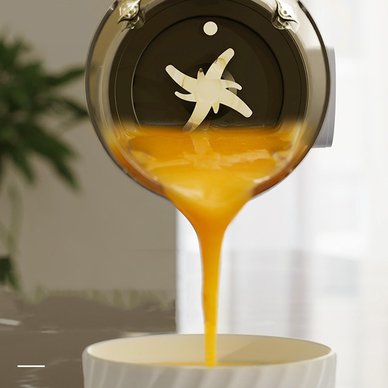 Orangensaft, der aus einem Mixer in einen weißen Behälter gegossen wird.