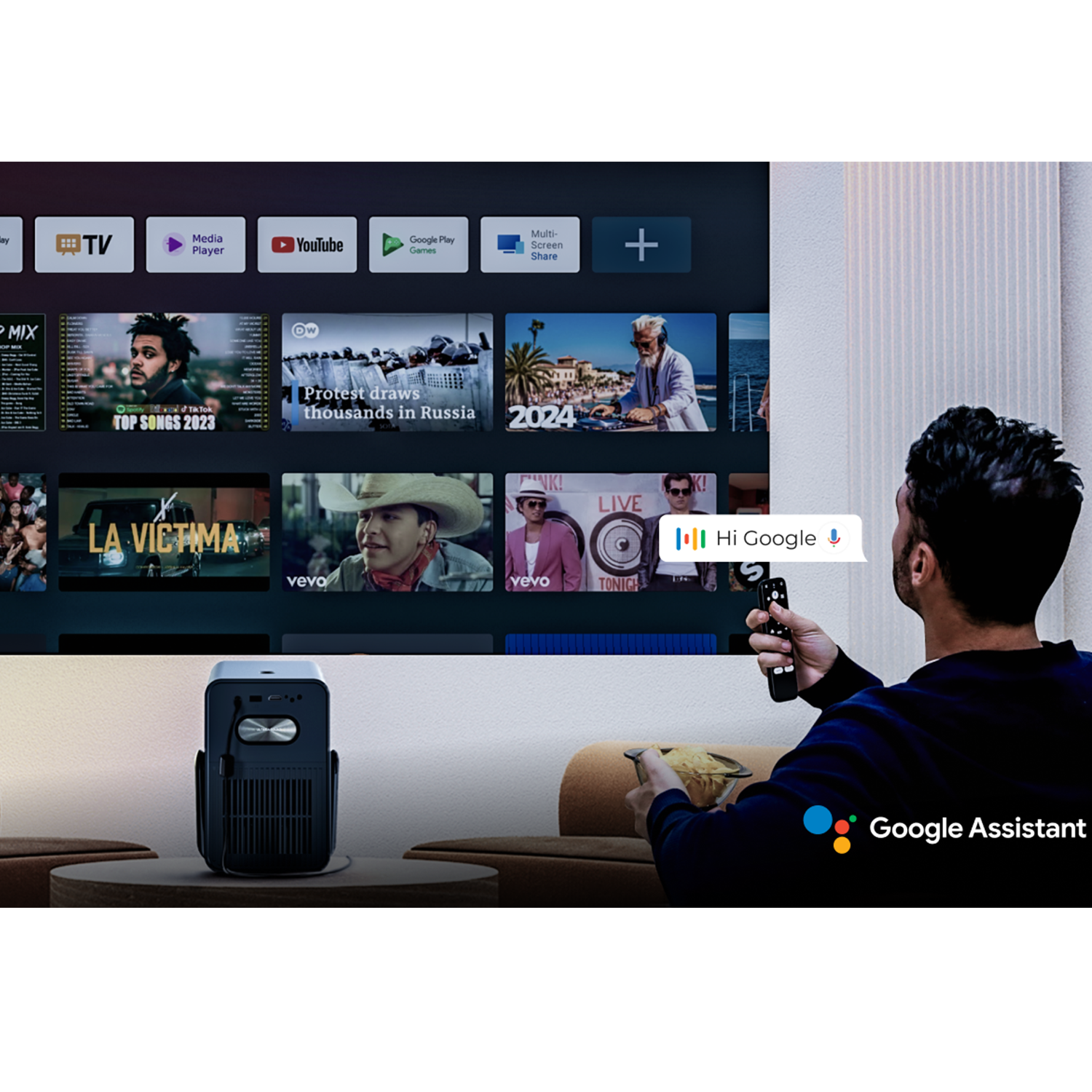 Una persona usa un mando a distancia con el Asistente de Google para controlar un proyector.