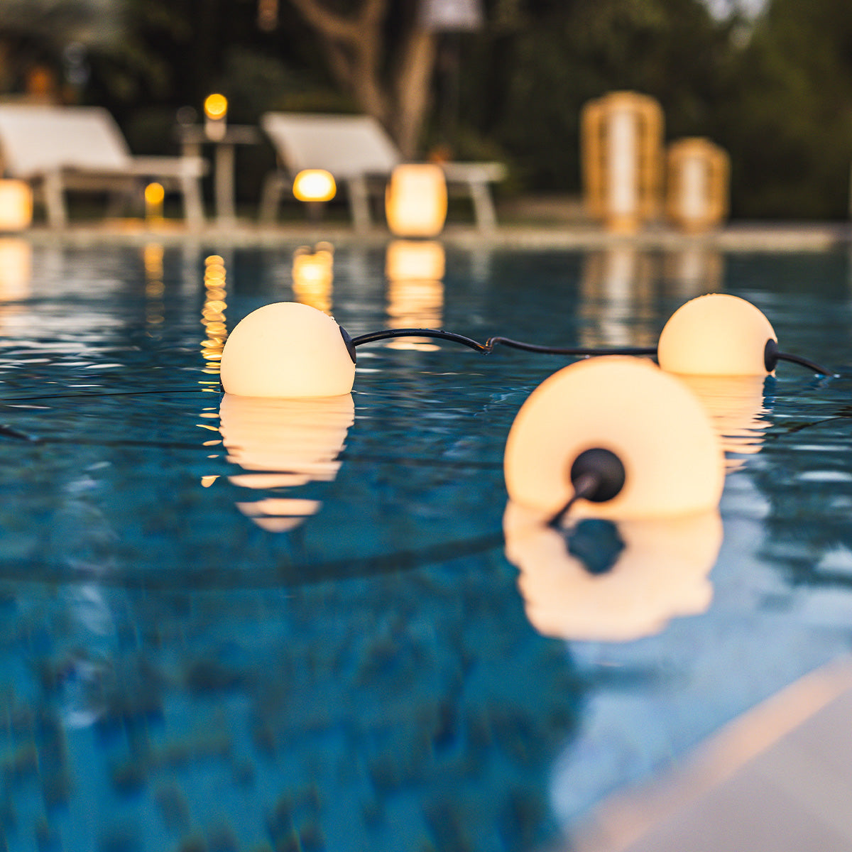 Lichter in einem Pool. Die Lichter sind weiße Kugeln. Der Hintergrund ist ein Pool.