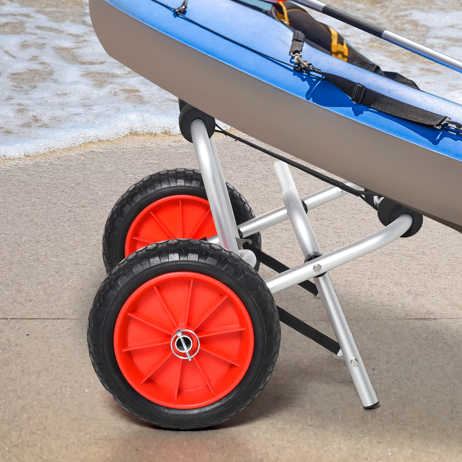 Blaues Kajak am Strand, unterstützt von einem Wagen mit orangen Rädern.