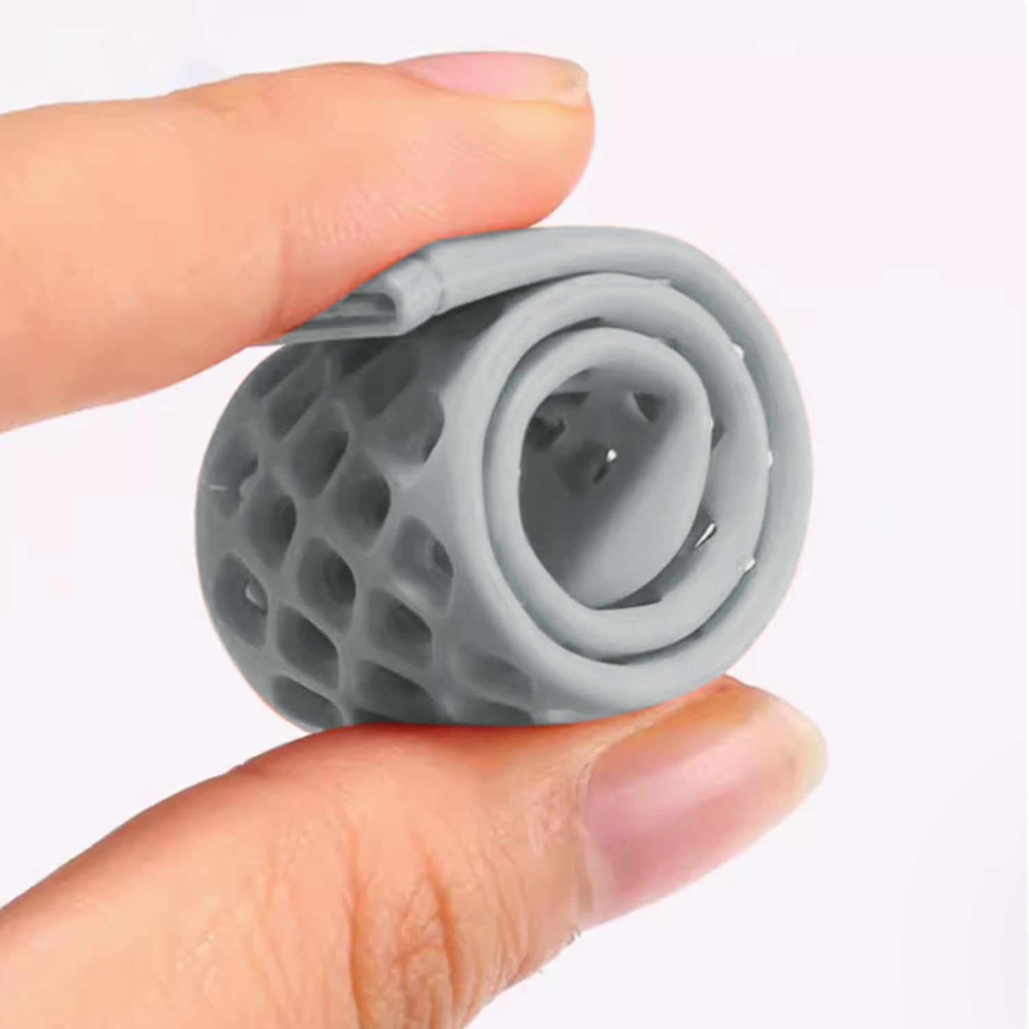 Szary, elastyczny, o wzorze plastra miodu, zwinięty przedmiot trzymany palcami.